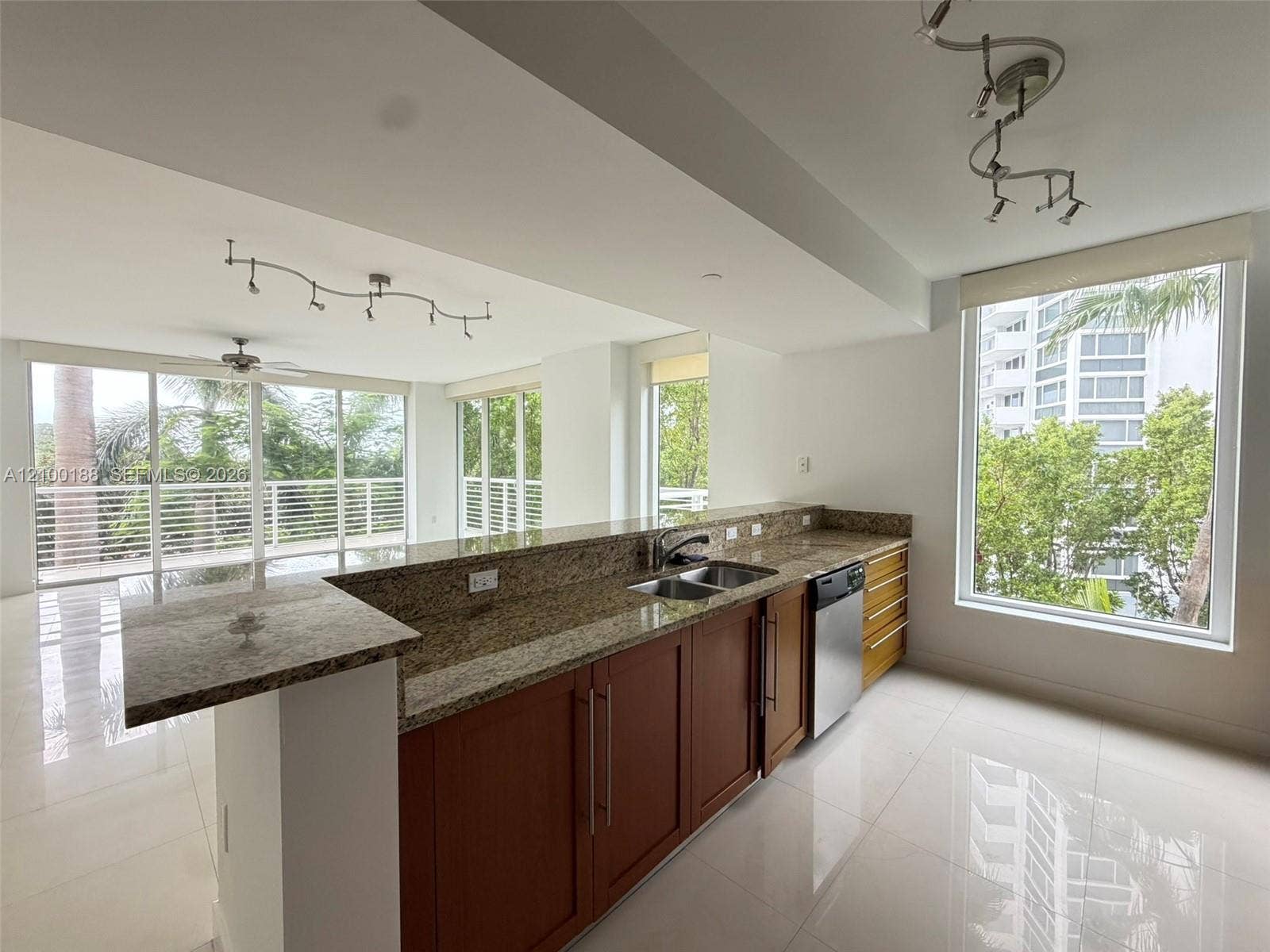 2821 N Ocean Boulevard, #305S, Fort Lauderdale, Fort Lauderdale, FL 33308 Kitchen featuring stone countertops, wood-finish cabinetry, stainless steel dishwasher, tile flooring, and track lighting