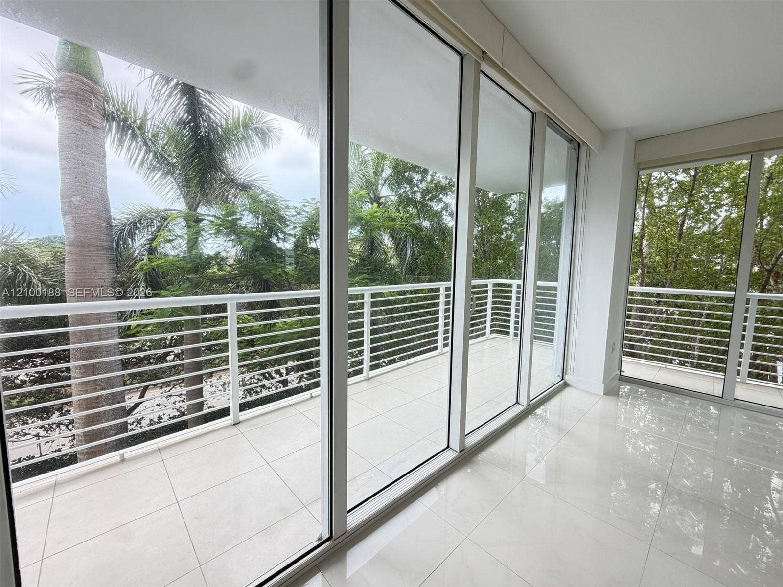 2821 N Ocean Boulevard, #305S, Fort Lauderdale, Fort Lauderdale, FL 33308 Floor-to-ceiling glass sliding doors, white tiled flooring, and a wrap-around balcony featuring white horizontal railings