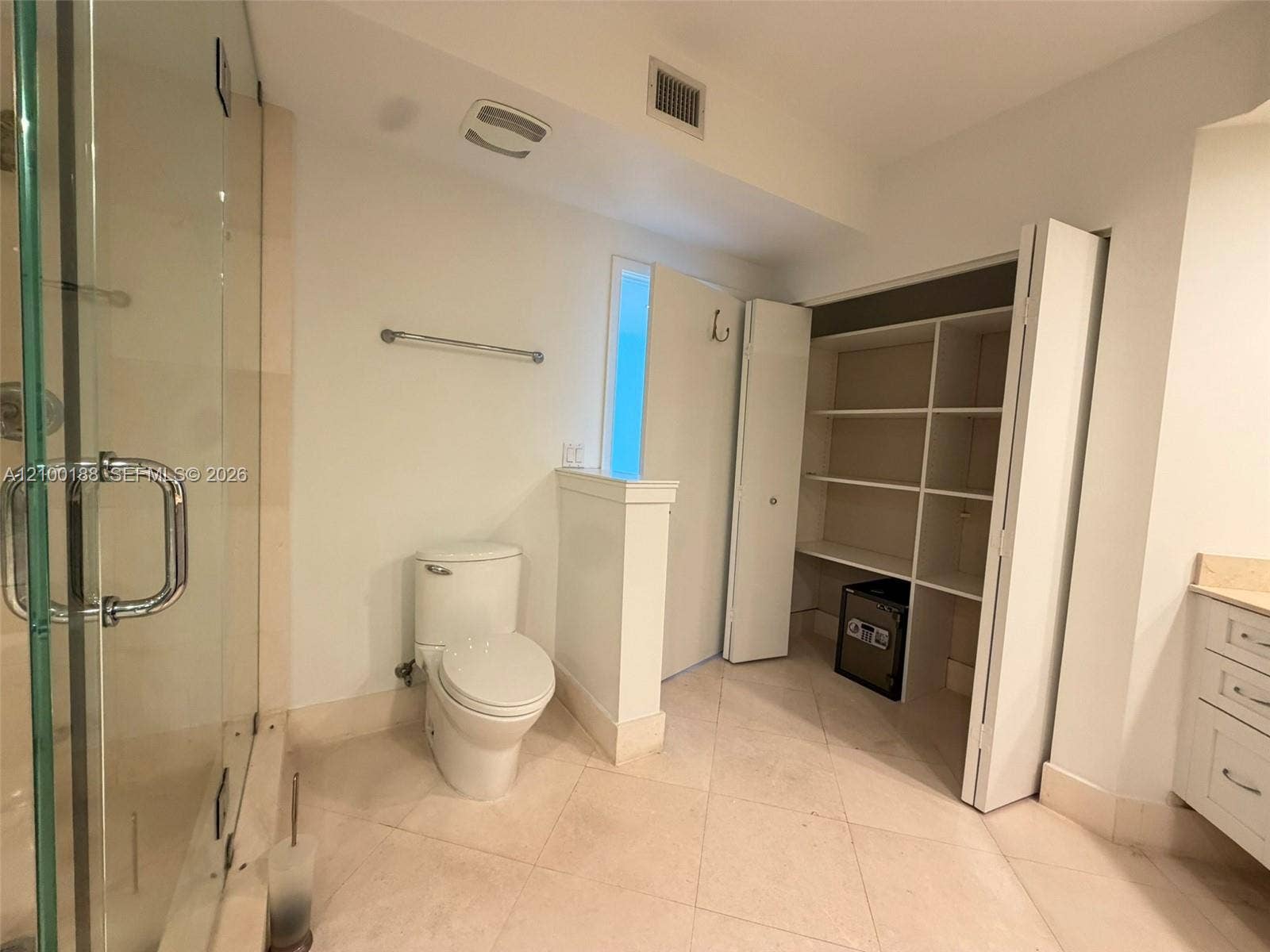 2821 N Ocean Boulevard, #305S, Fort Lauderdale, Fort Lauderdale, FL 33308 Bathroom featuring a glass-enclosed shower, tile flooring, built-in open shelving, and white cabinetry with a light-toned countertop