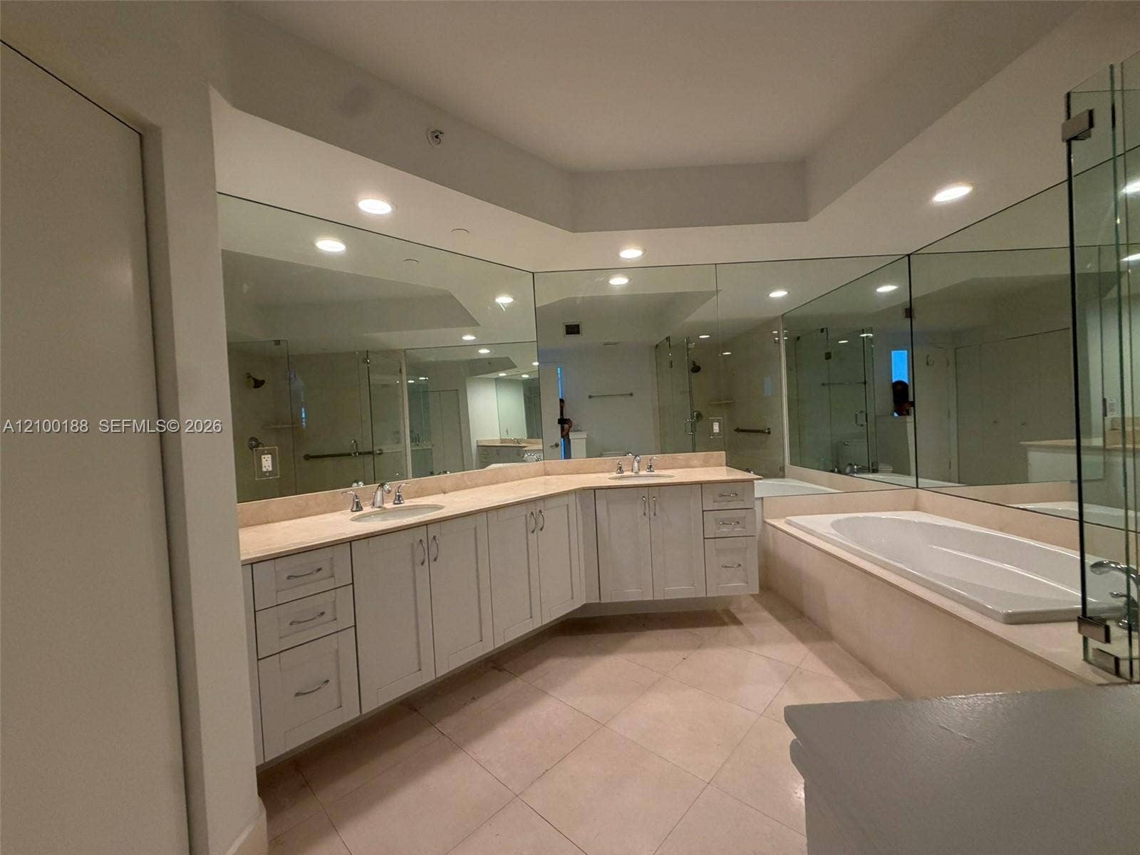 2821 N Ocean Boulevard, #305S, Fort Lauderdale, Fort Lauderdale, FL 33308 Dual vanity featuring light-toned cabinetry, a neutral countertop, recessed lighting, expansive wall mirrors, and an integrated soaking tub