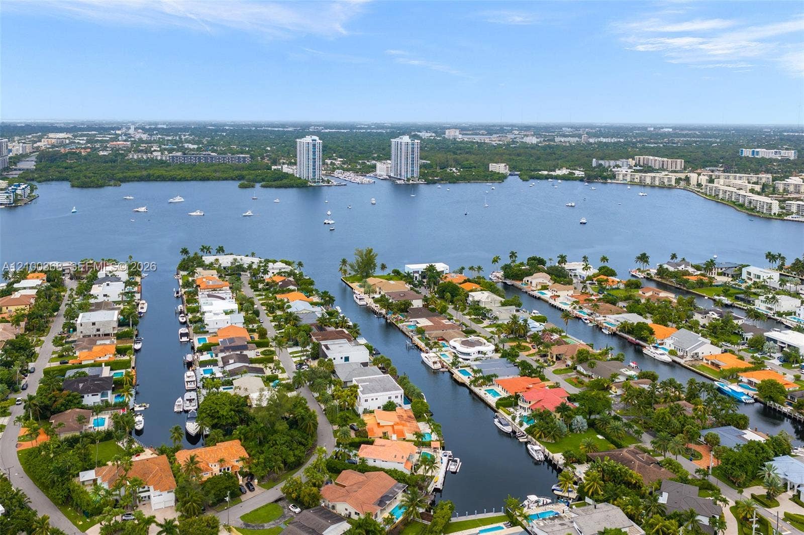 Aerial perspective of a waterfront residential enclave featuring deep-water canal access, private boat slips, and direct waterway frontage