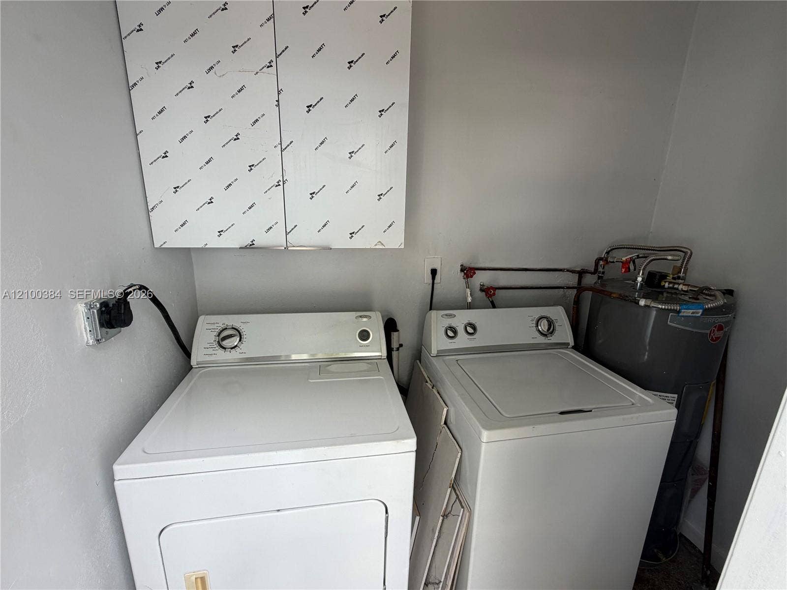 3100 SW 67th Terrace, Miramar, FL 33023 Laundry area featuring upper wall-mounted cabinetry and a standard water heater