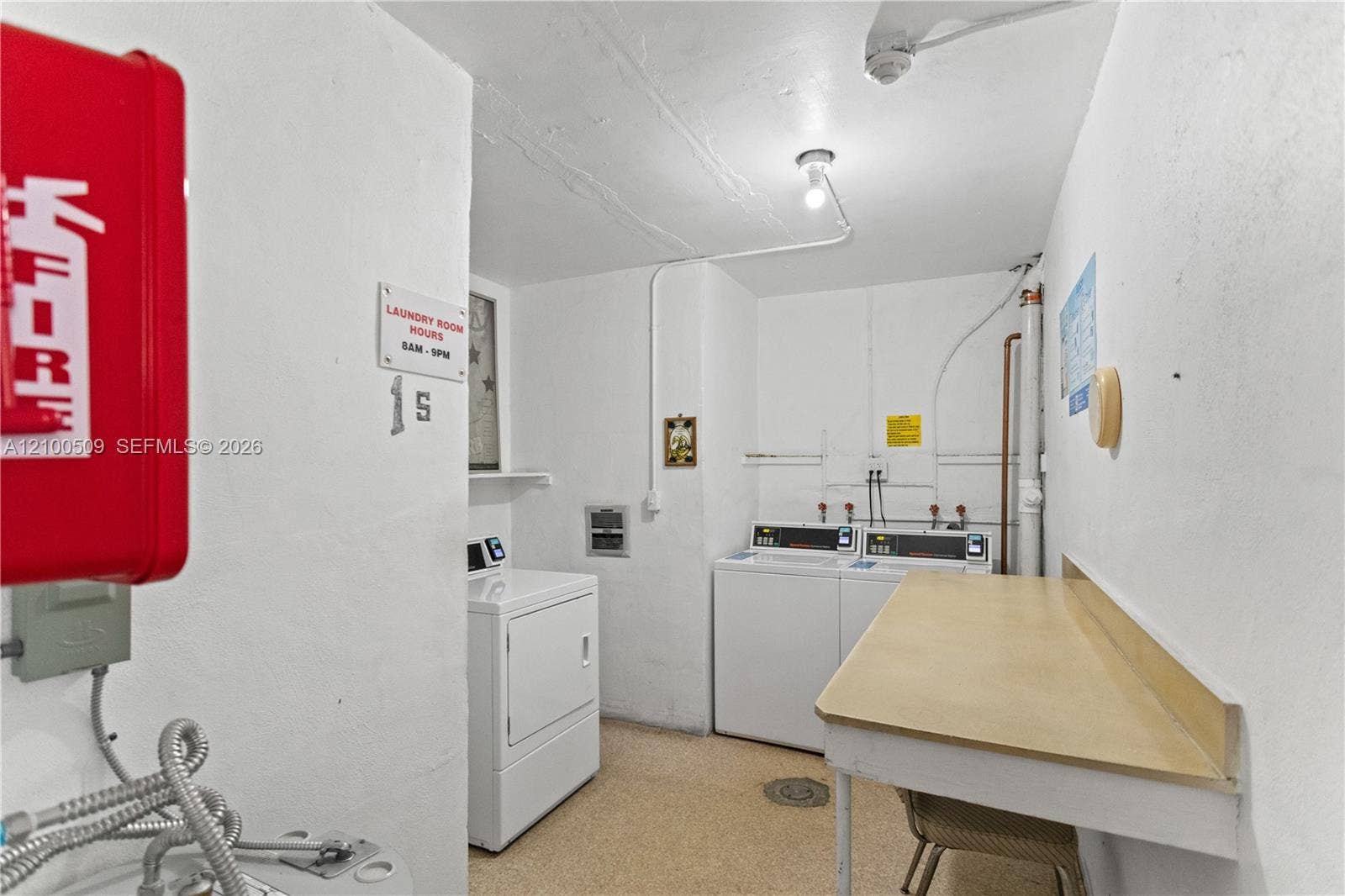 Laundry room with multiple washing machines and a dedicated folding counter