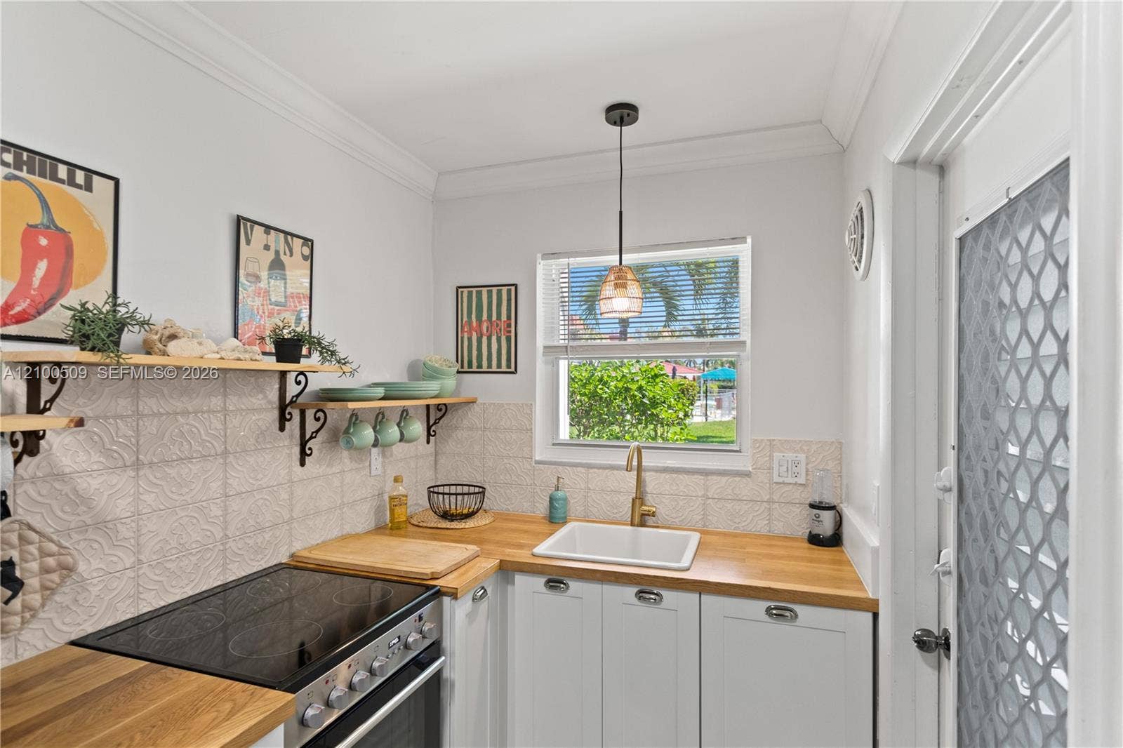 Kitchen featuring wood countertops, white cabinetry, and decorative tile backsplash