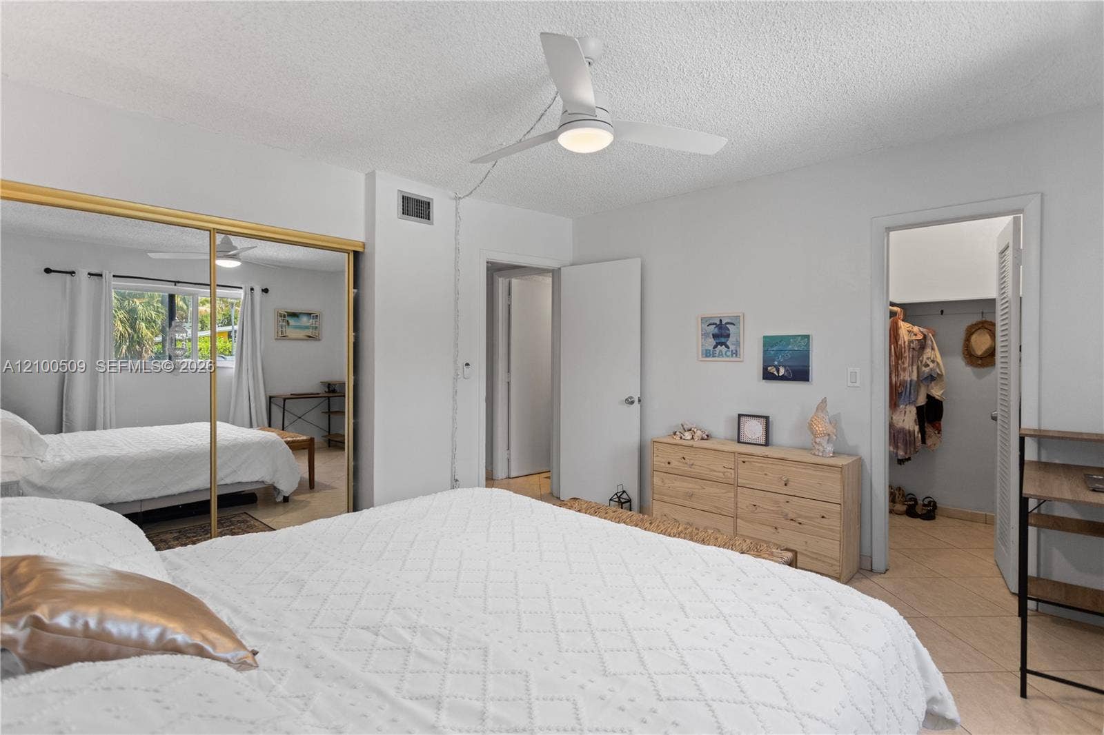 Spacious bedroom with mirrored closet doors and a walk-in