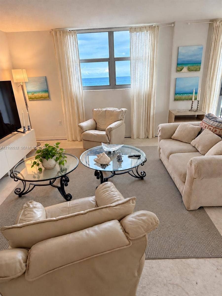 9273 Collins Avenue, #912, Surfside, Surfside, FL 33154 Living space featuring polished stone flooring, large picture window with ocean backdrop, and light-filled neutral interior
