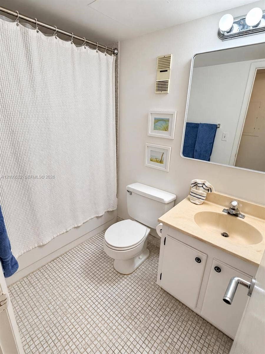 9273 Collins Avenue, #912, Surfside, Surfside, FL 33154 Bathroom featuring a vanity with integrated sink, rectangular wall-mounted mirror, two-light fixture, and tiled flooring