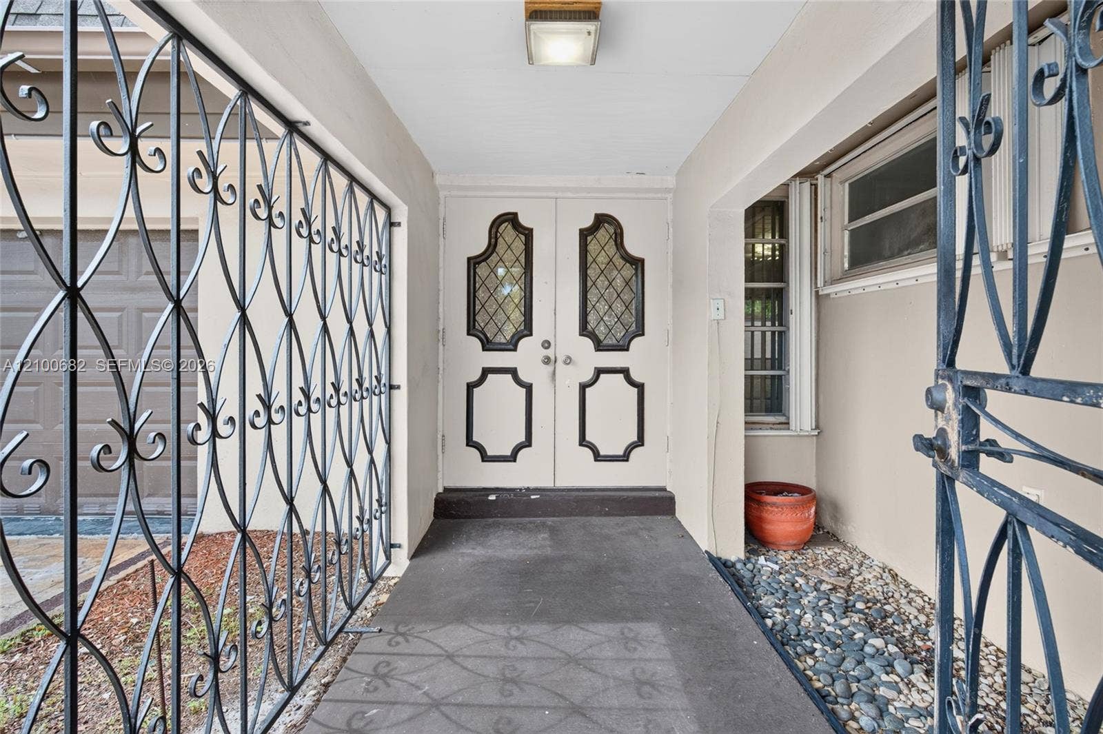 8402 SW 102nd Court, Miami, FL 33173 Double entry doors featuring leaded glass panes and decorative molding, protected by custom wrought iron security screening