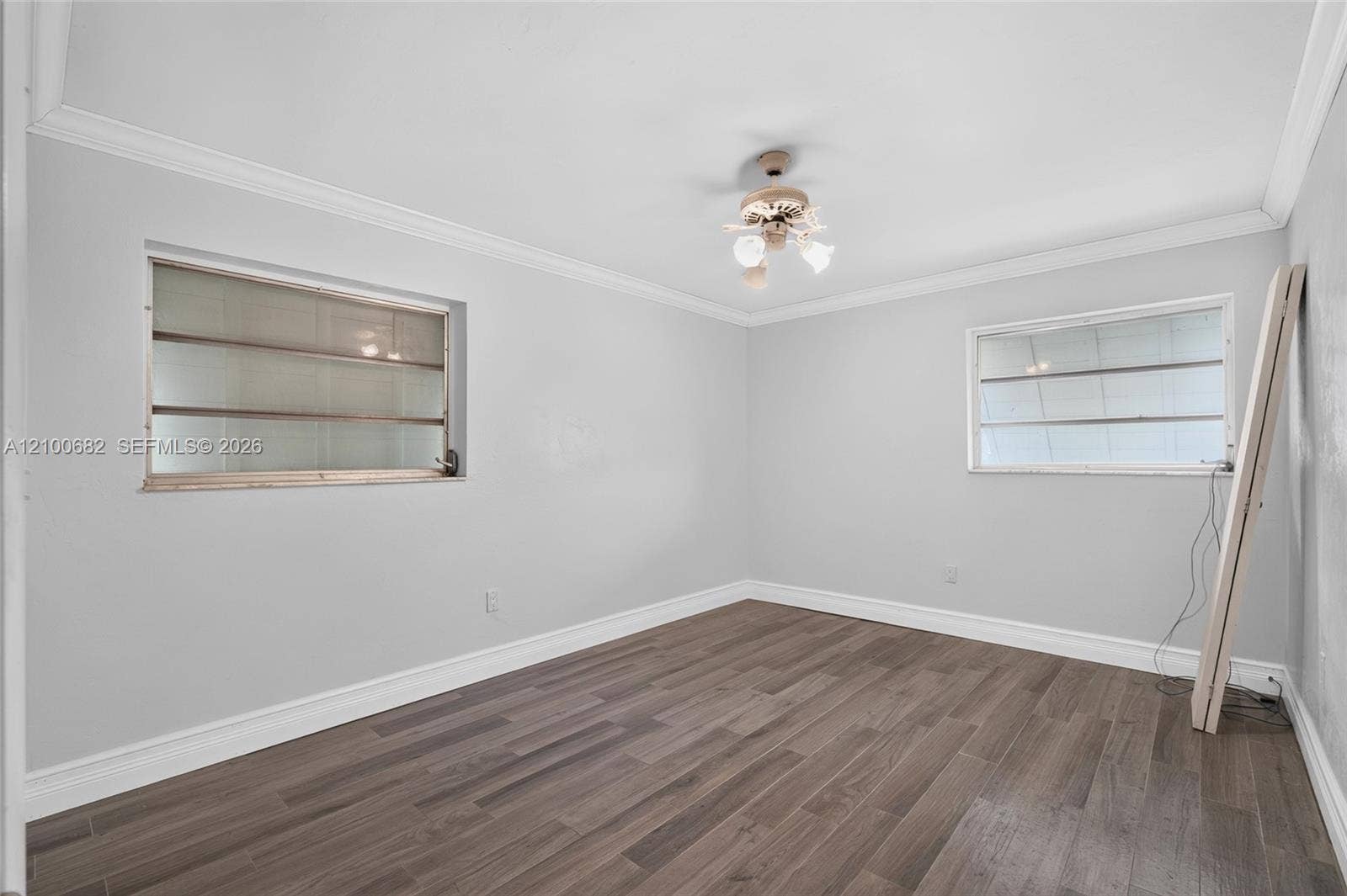 8402 SW 102nd Court, Miami, FL 33173 Third bedroom featuring vinyl wood-finish flooring, neutral wall tones, crown molding and newer baseboards*