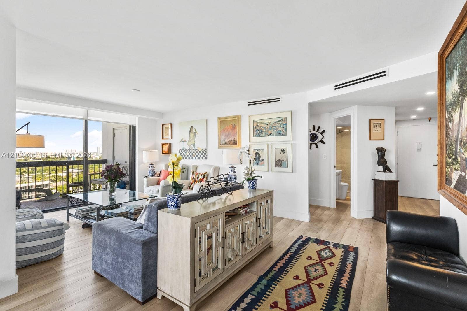 Living area featuring wood-finish flooring, floor-to-ceiling windows, and recessed lighting