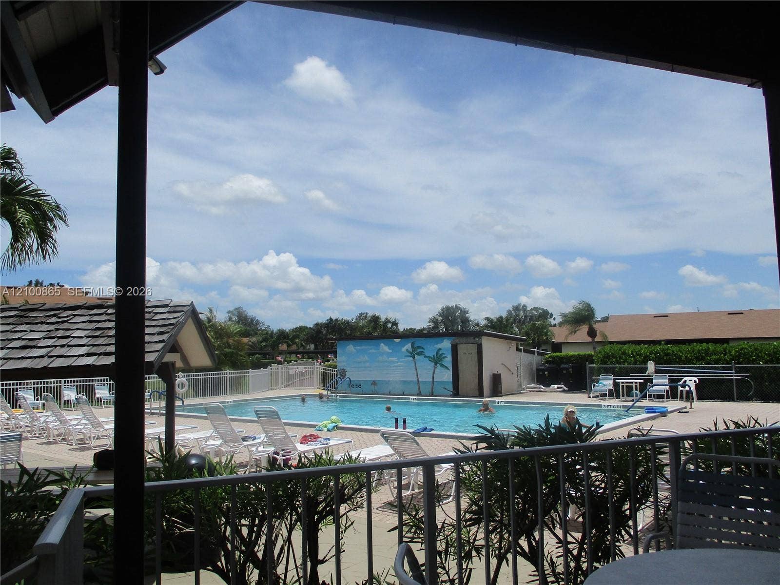 6531 SE Federal Highway, #J112, Stuart, FL 34997 Outdoor swimming pool featuring a concrete deck and a perimeter metal fence with a shaded area