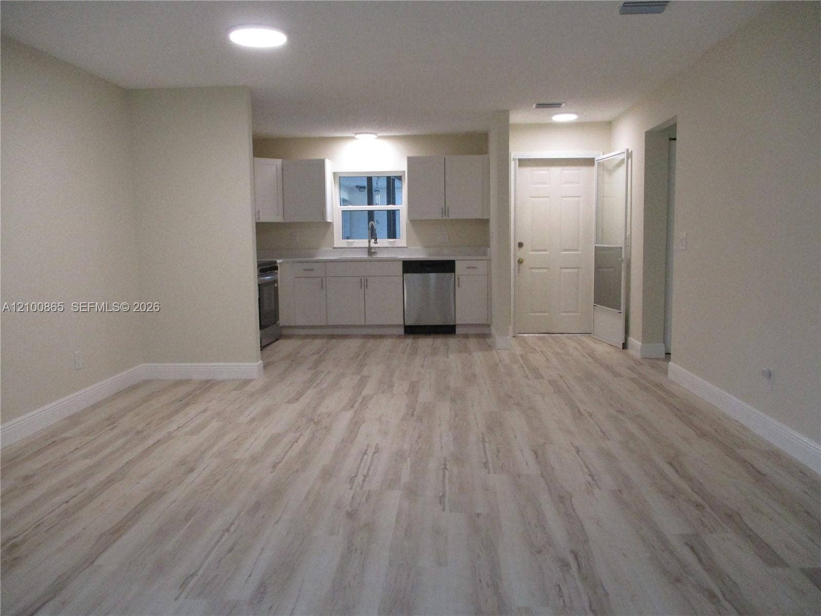 6531 SE Federal Highway, #J112, Stuart, FL 34997 Kitchen area featuring light-toned cabinetry, stainless steel appliances, and wood-finish flooring