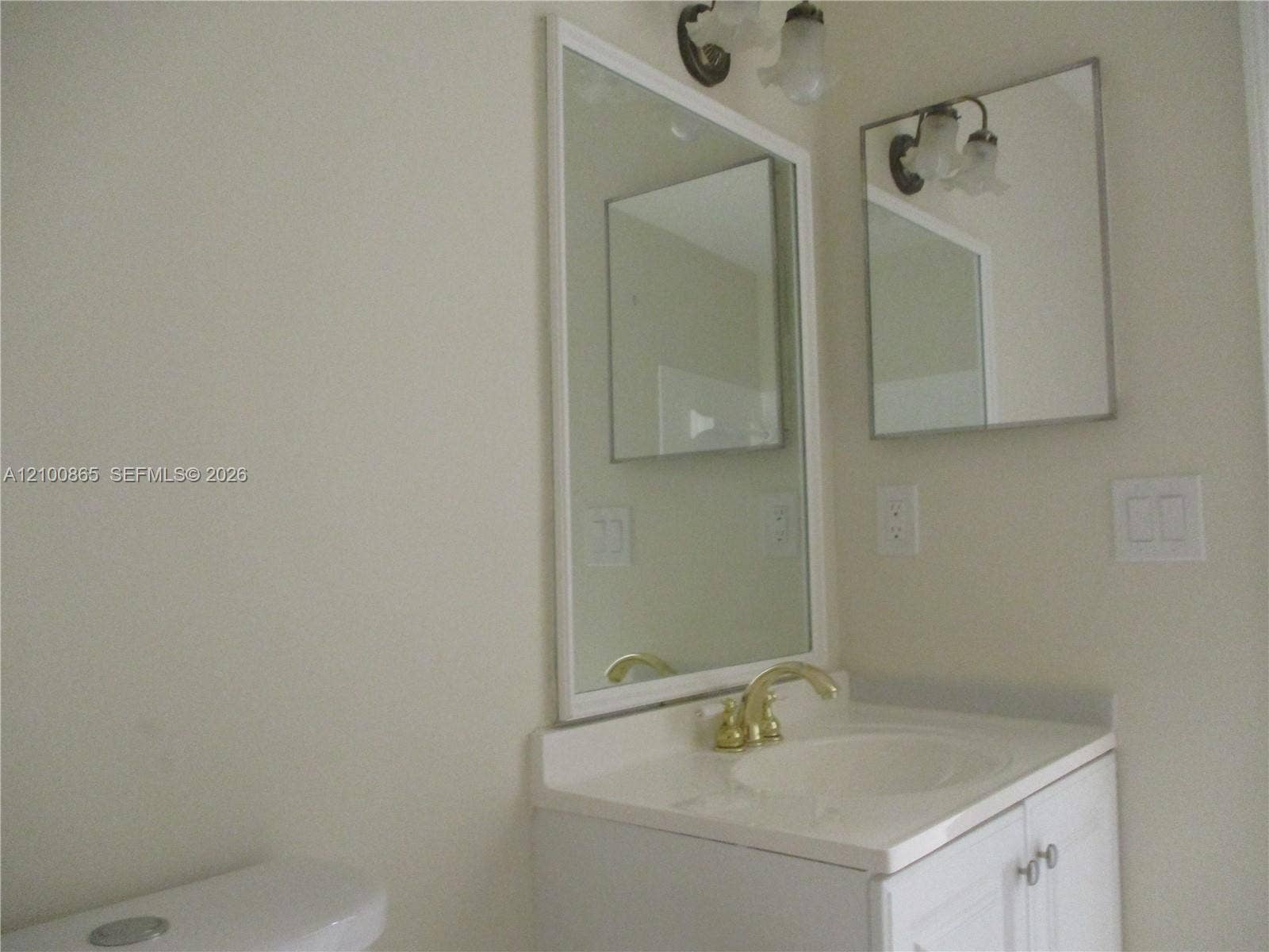 6531 SE Federal Highway, #J112, Stuart, FL 34997 Guest bath with White vanity with a gold-finish faucet, an integrated sink