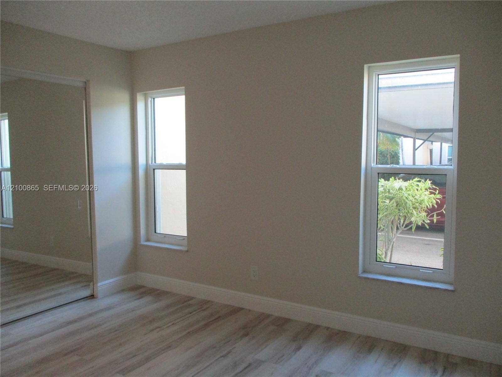6531 SE Federal Highway, #J112, Stuart, FL 34997 Guest Room featuring wood-finish flooring, dual windows, and a mirrored closet door