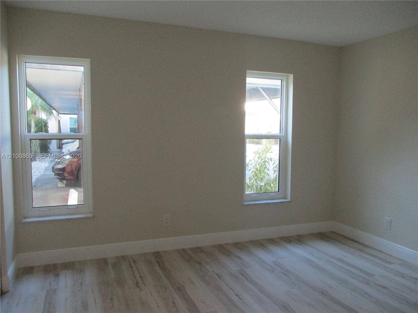 6531 SE Federal Highway, #J112, Stuart, FL 34997 Guest room with Neutral-toned interior walls featuring dual double-hung windows and wood-finish flooring