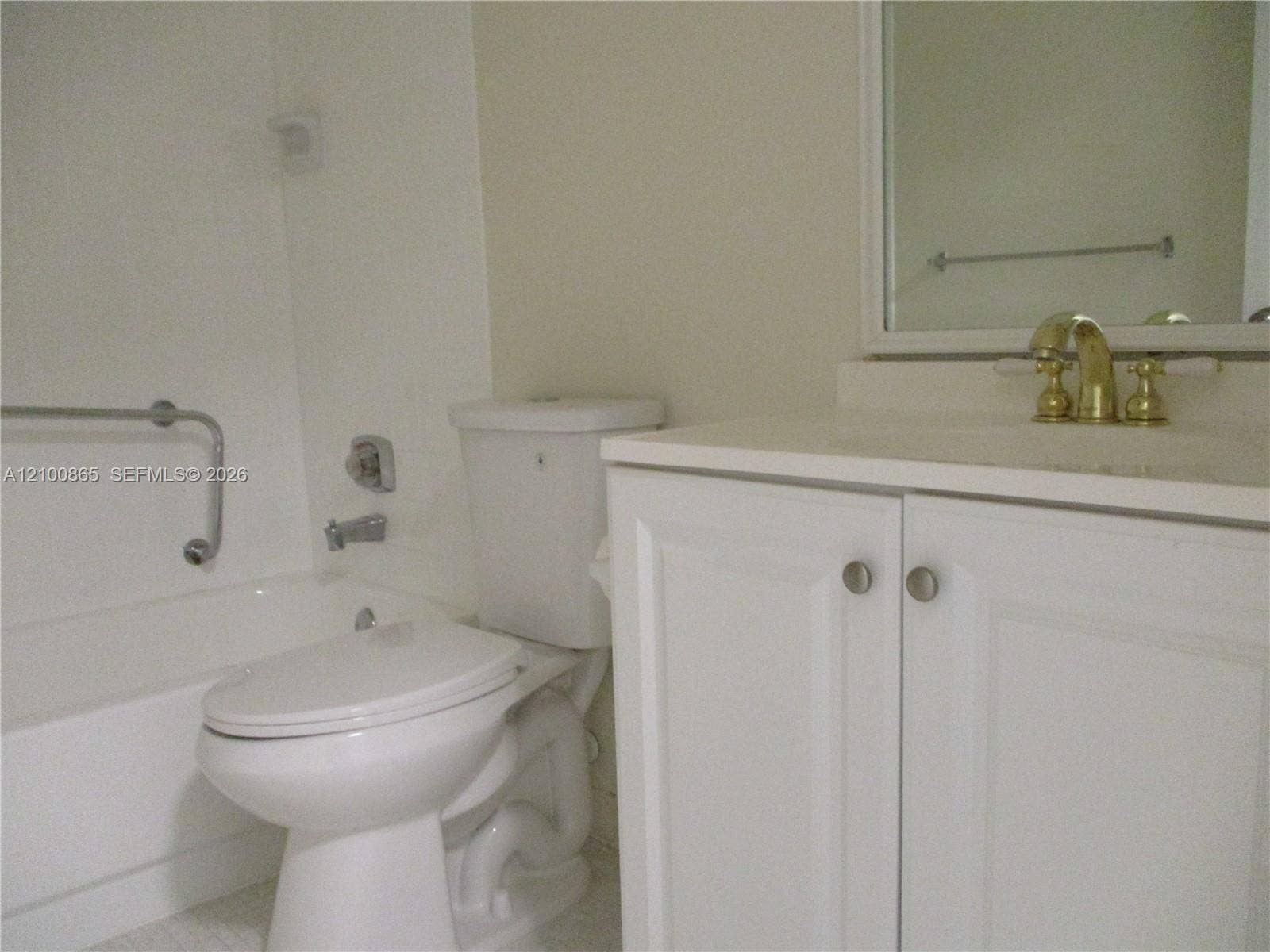 6531 SE Federal Highway, #J112, Stuart, FL 34997 Guest bathroom with White vanity cabinet storage, brass-finish faucet, and integrated sink