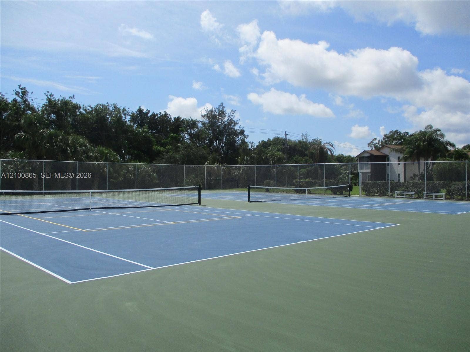 6531 SE Federal Highway, #J112, Stuart, FL 34997 Dual hard-court tennis/pickle ball facility featuring blue and green surfacing, white court markings, central nets, and full-perimeter chain-link fencing