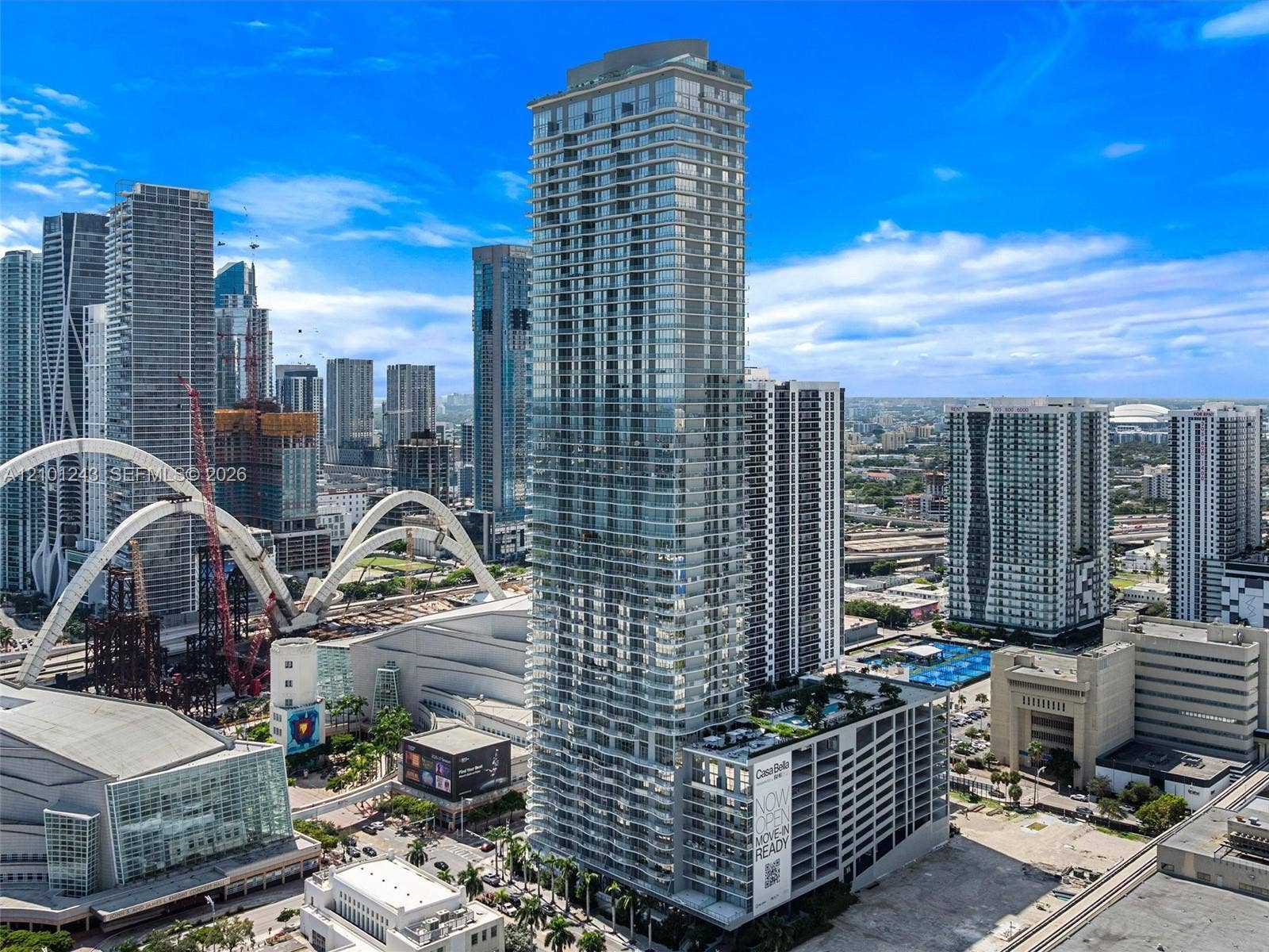 High-rise architectural tower featuring floor-to-ceiling glass paneling, a multi-level structure, private balconies, and an elevated outdoor deck