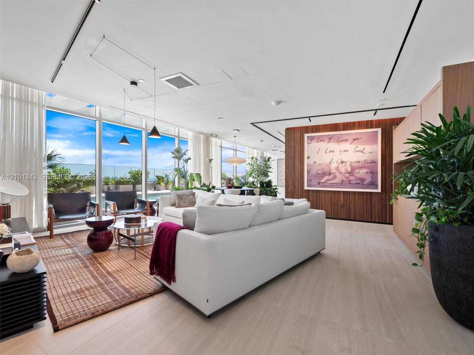 Floor-to-ceiling glass walls, wood-finish flooring, linear track lighting, and a floor-to-ceiling wood-panel feature wall