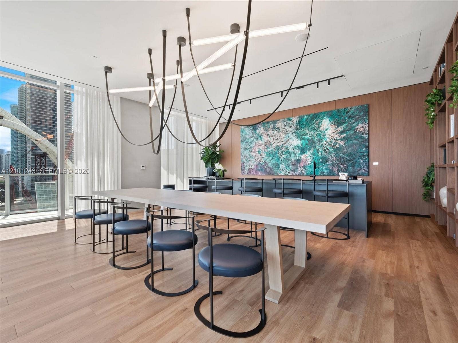 Floor-to-ceiling glass windows, wide-plank wood-finish flooring, custom wood-panel wall integration, integrated floor-to-ceiling shelving, and sculptural linear LED chandelier
