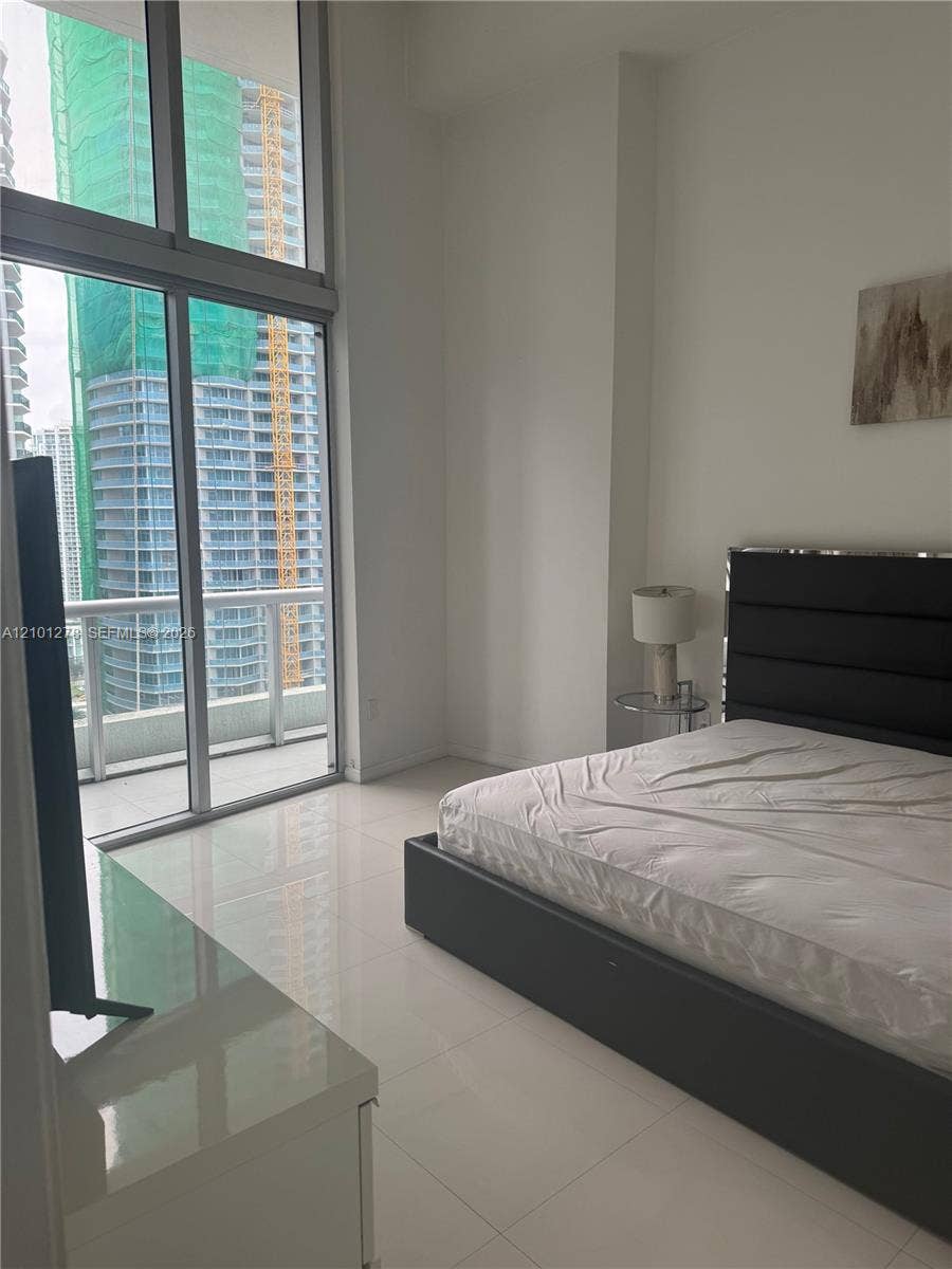 485 Brickell Avenue, #2806, Miami, Miami, FL 33131 Floor-to-ceiling windows, high ceilings, glass-paneled balcony access, and polished tile flooring