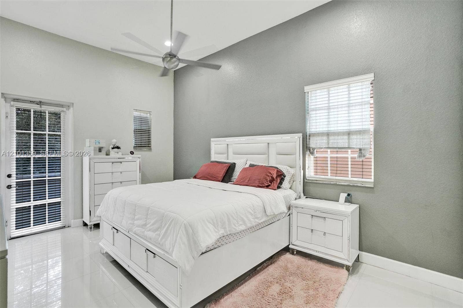 859 SW 147th Terrace, #0, Pembroke Pines, FL 33027 High-ceilinged bedroom featuring glossy tile flooring, a multi-blade ceiling fan, and a glass-paned exterior door