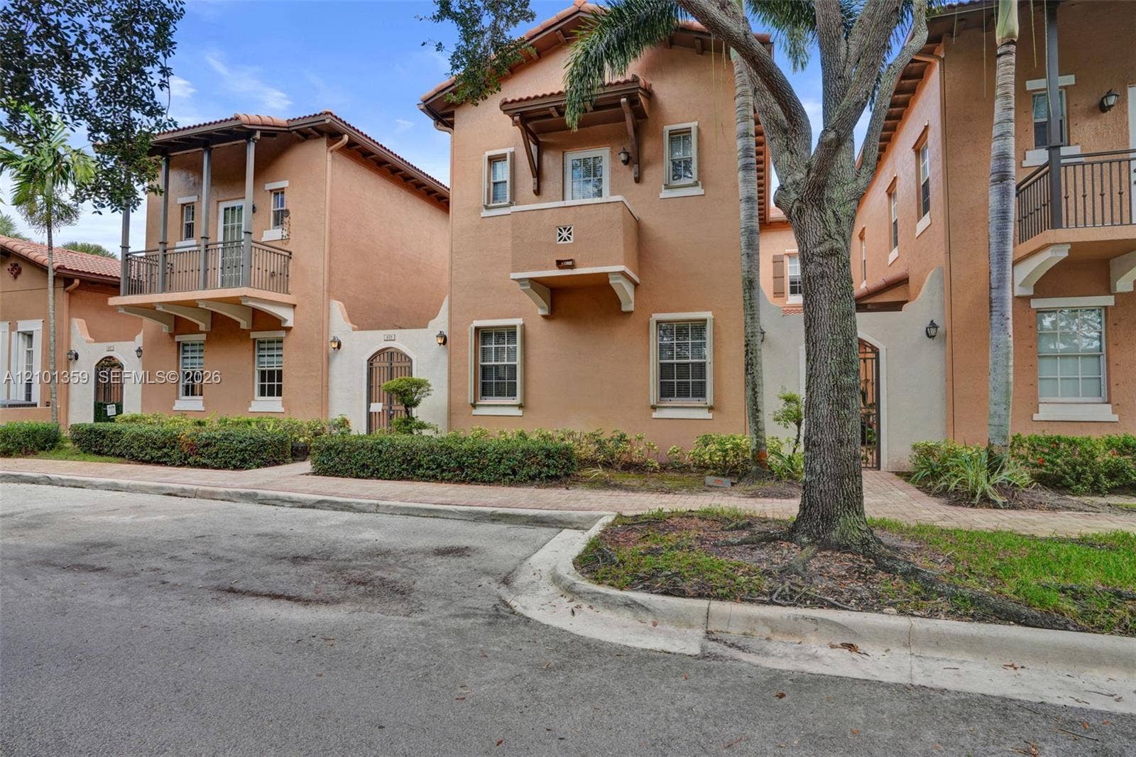 859 SW 147th Terrace, #0, Pembroke Pines, FL 33027 Mediterranean-inspired exterior featuring stucco facades, tile roofing, decorative balconies with wrought-iron railings, arched entryway gates, and multi-pane windows