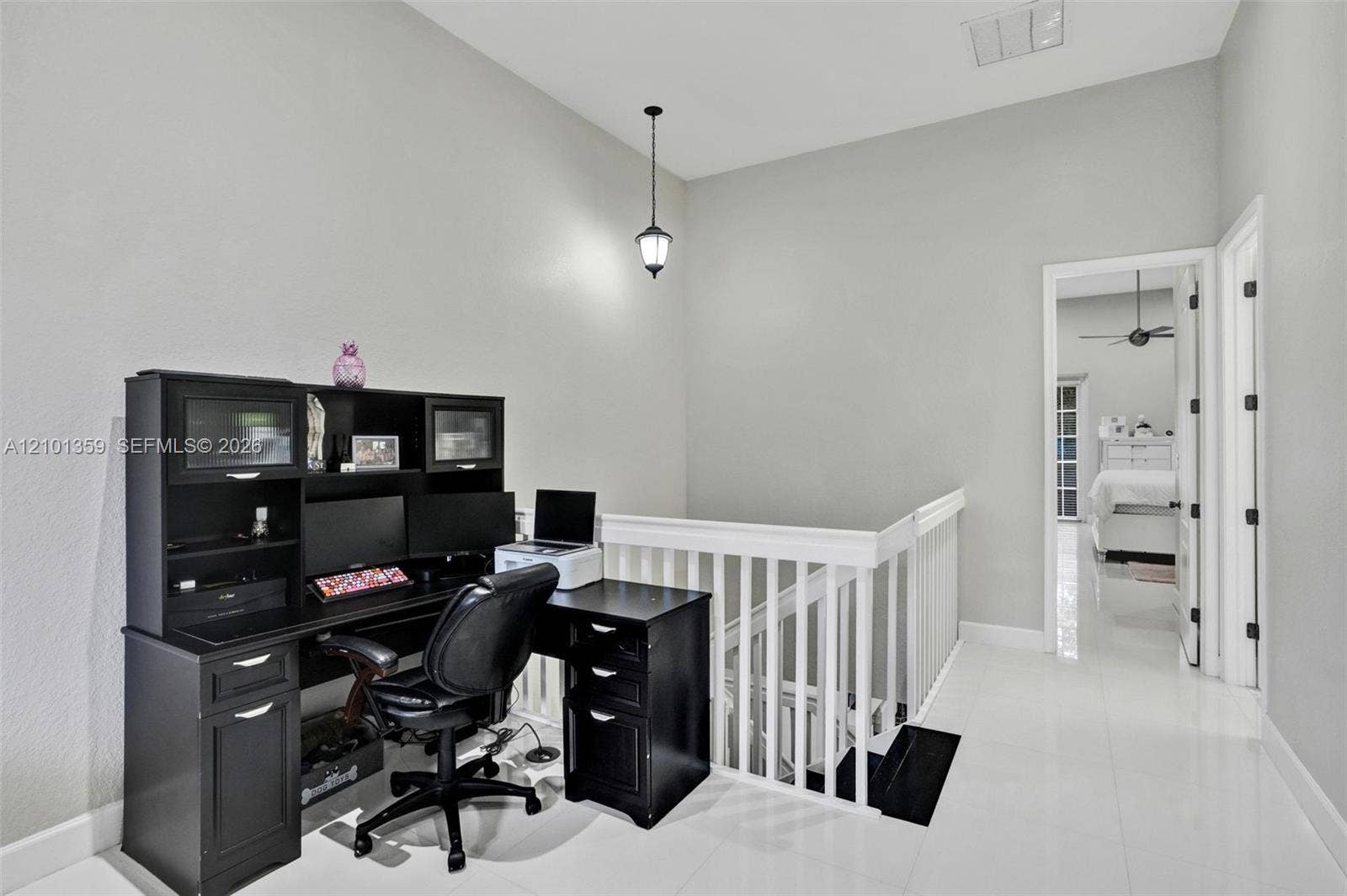 859 SW 147th Terrace, #0, Pembroke Pines, FL 33027 High-ceiling landing featuring glossy tile flooring, a white wooden balustrade, and a hanging pendant light