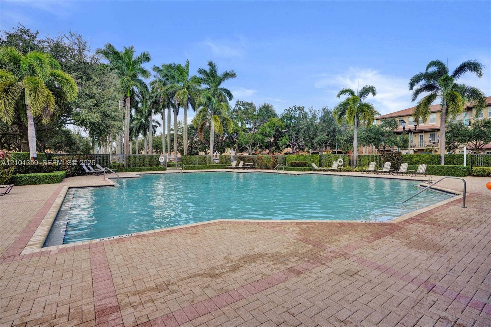 859 SW 147th Terrace, #0, Pembroke Pines, FL 33027 Swimming pool with stone-paver decking, perimeter landscaping, and mature palm trees