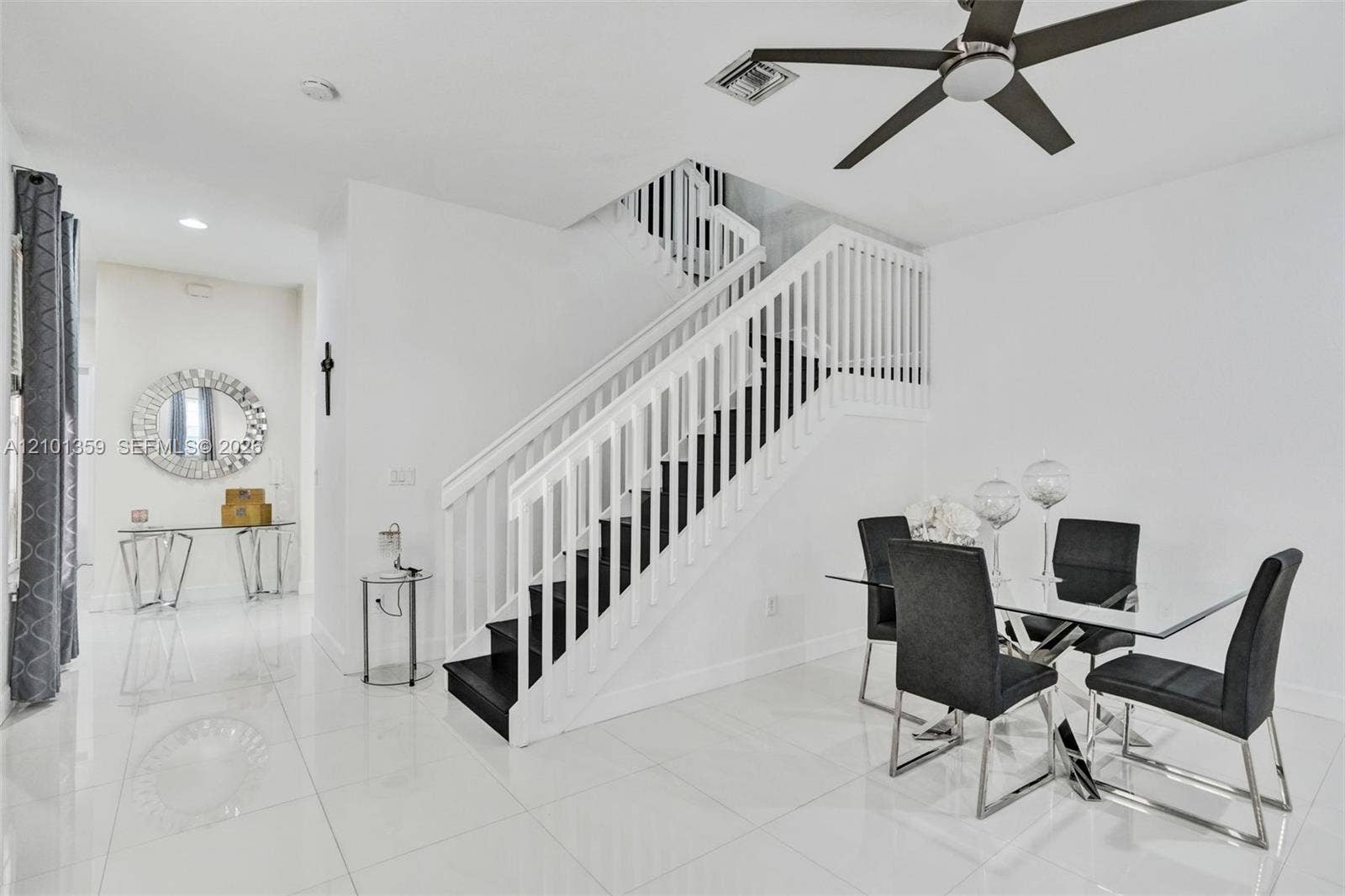 859 SW 147th Terrace, #0, Pembroke Pines, FL 33027 Staircase featuring white balusters and a contrasting dark-toned tread design, polished tile flooring, and a modern ceiling fan