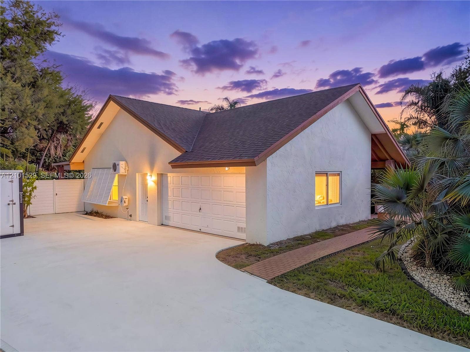 16761 SW 278th Street, Homestead, FL 33031 Stucco exterior with a peaked roof, attached garage, and a concrete driveway