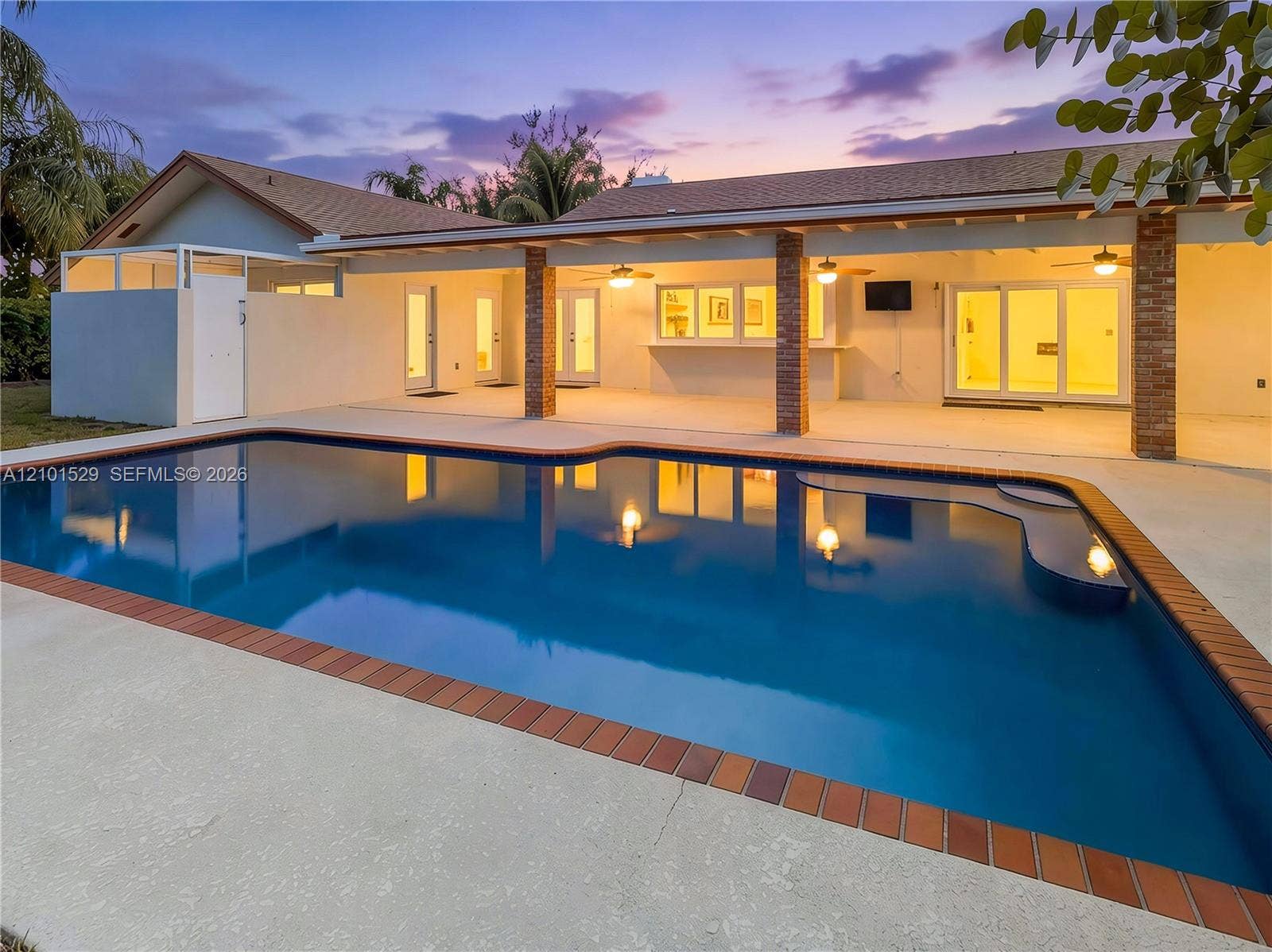 16761 SW 278th Street, Homestead, FL 33031 Spacious outdoor pool area featuring a built-in pool, expansive concrete patio, covered patio with brick columns, and a built-in outdoor bar