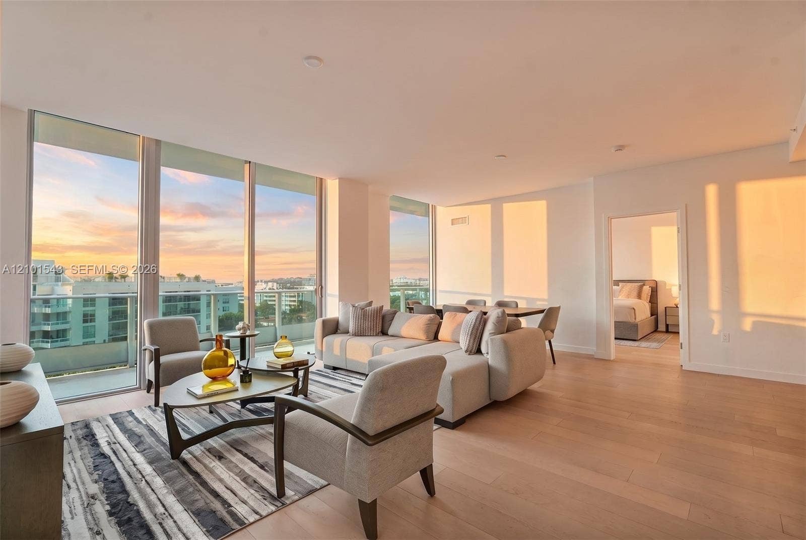 Floor-to-ceiling windows, wood-finish flooring, recessed lighting, and a glass-railing balcony
