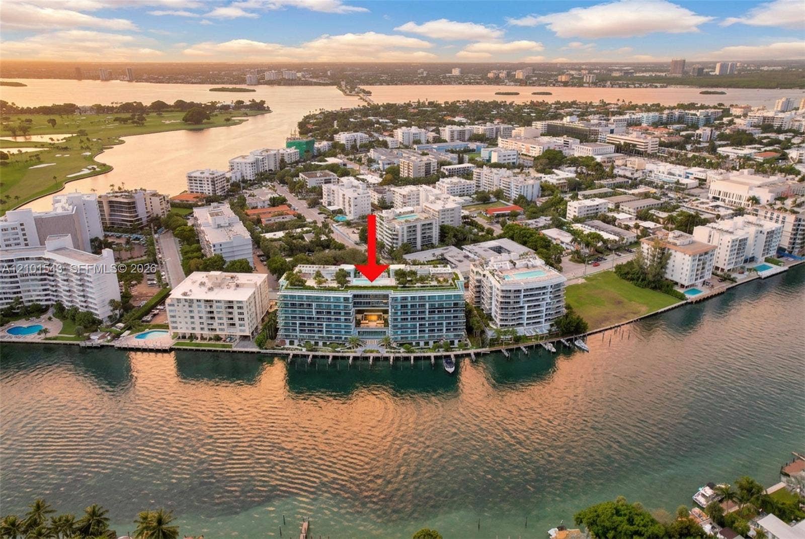 Waterfront mid-rise building featuring a rooftop pool, expansive balcony terraces, and direct canal access