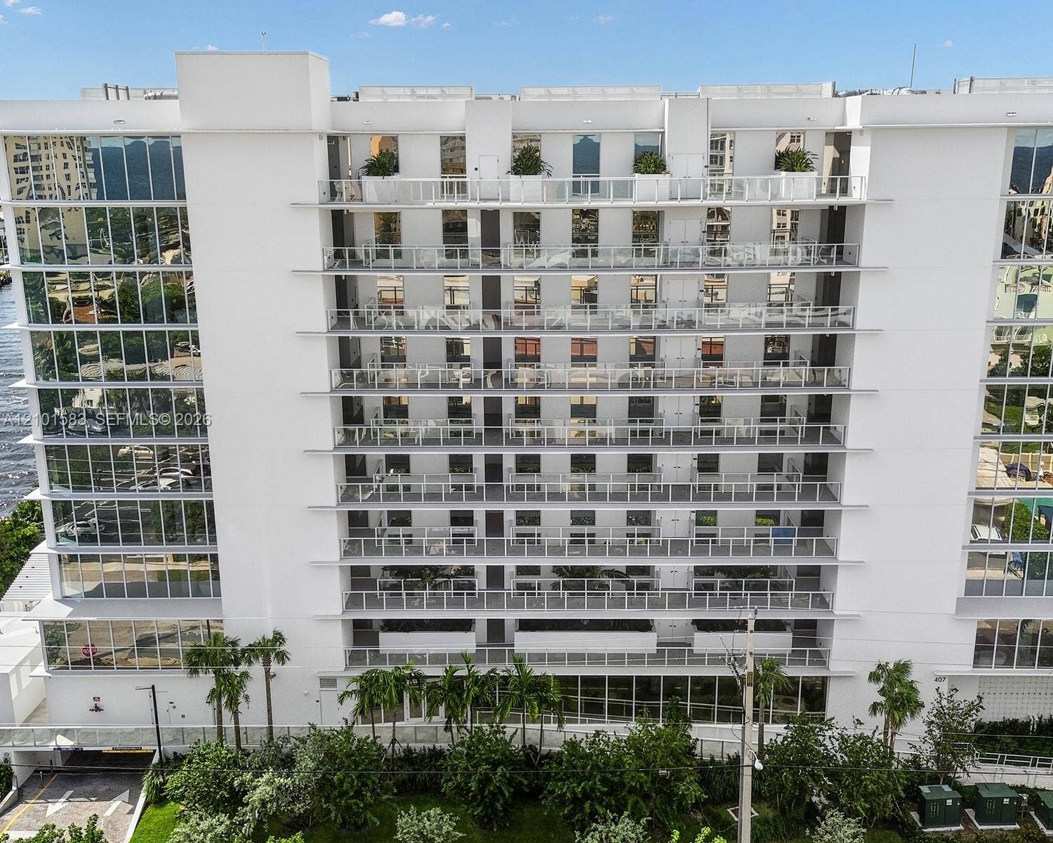 407 N Riverside Drive, #604, Pompano Beach, Pompano Beach, FL 33062 Multi-story residential building exterior featuring floor-to-ceiling glass windows, individual private balconies with glass railings, and incorporated container greenery