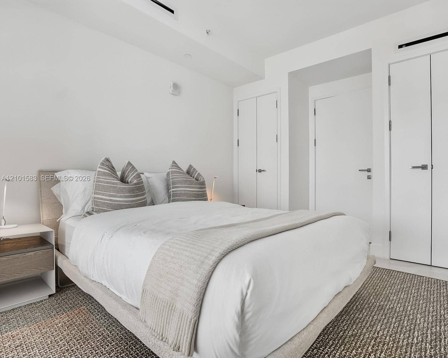 407 N Riverside Drive, #604, Pompano Beach, Pompano Beach, FL 33062 Neutral-toned interior space featuring crisp white walls, recessed ceiling lighting, and multiple floor-to-ceiling closets with minimalist hardware