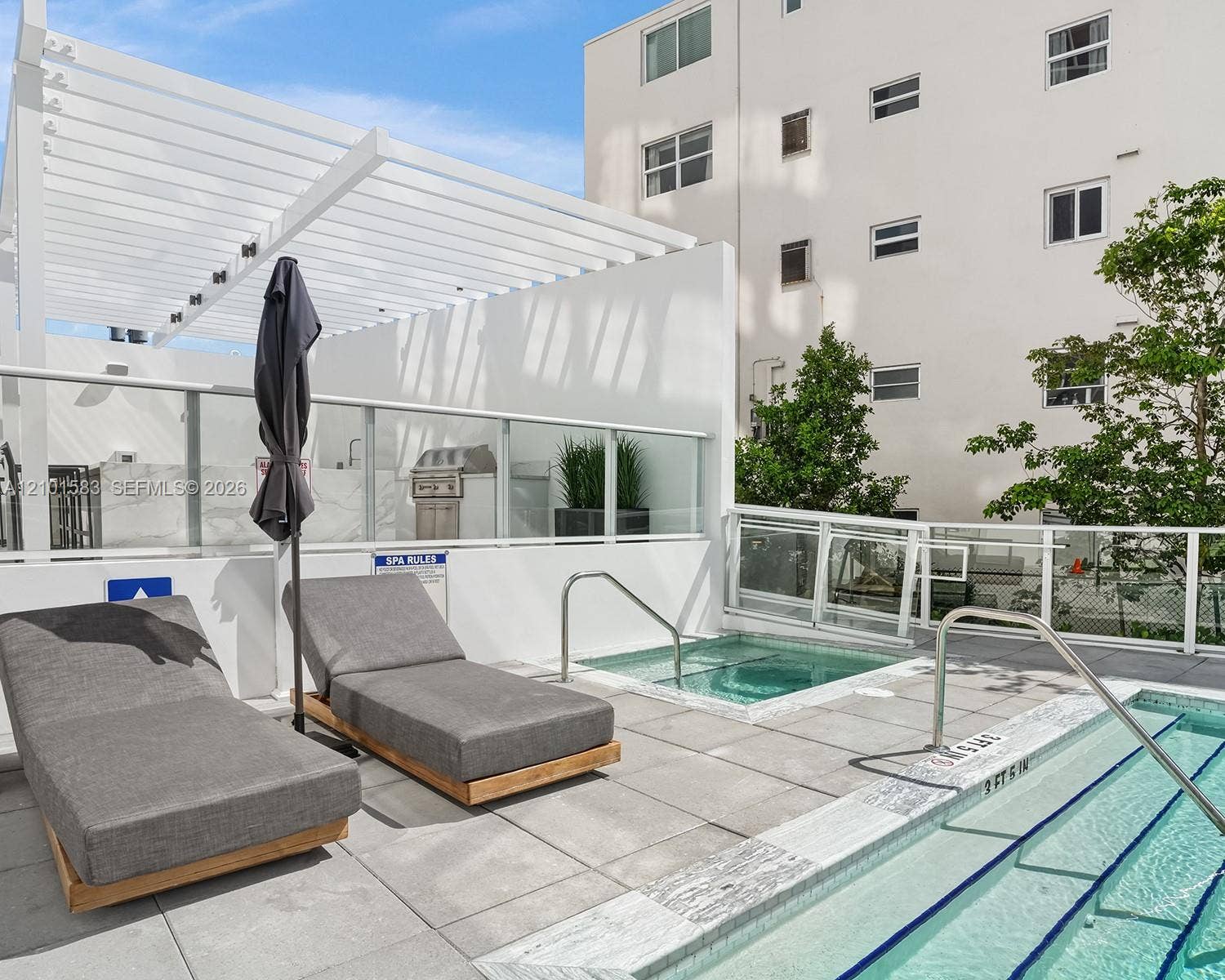 407 N Riverside Drive, #604, Pompano Beach, Pompano Beach, FL 33062 Rooftop terrace featuring a swimming pool, integrated spa, white aluminum pergola, built-in outdoor grill, and glass railing