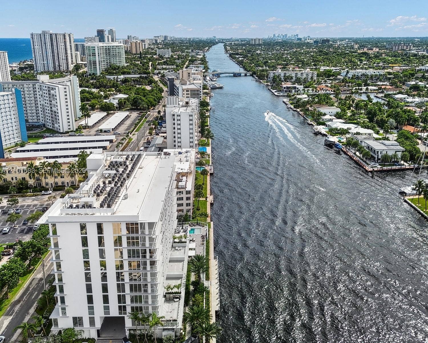 407 N Riverside Drive, #604, Pompano Beach, Pompano Beach, FL 33062 Waterfront high-rise building featuring a multi-story glass facade, dedicated ground-level swimming pool, and direct canal frontage