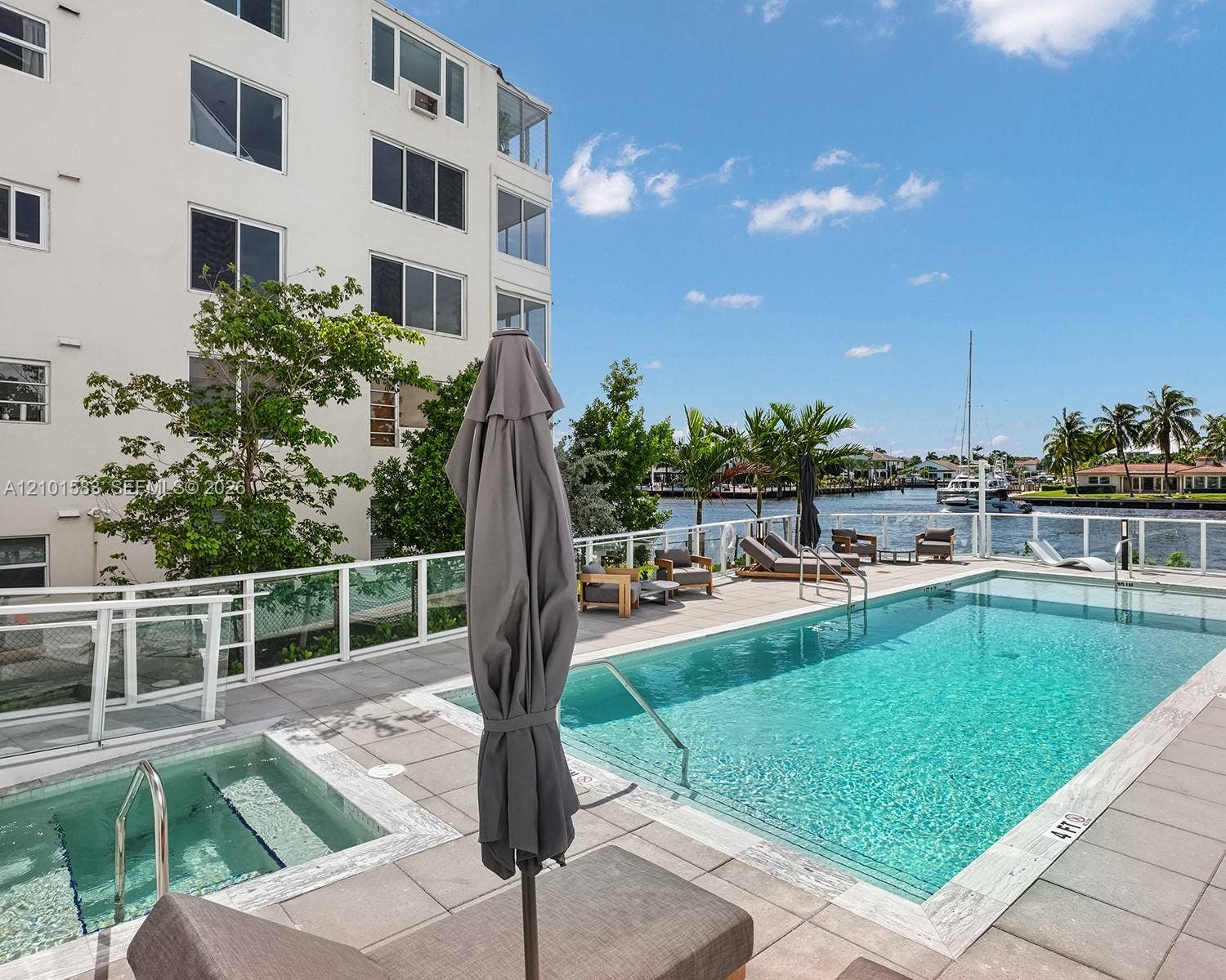407 N Riverside Drive, #604, Pompano Beach, Pompano Beach, FL 33062 Waterfront pool area featuring a built-in spa, concrete tile decking, and a glass-paneled safety railing
