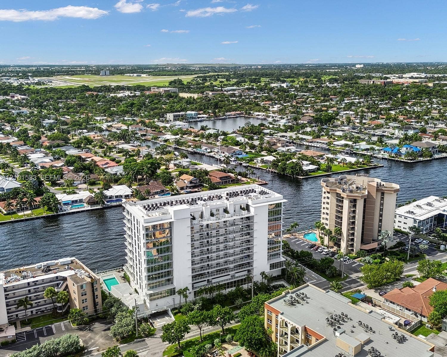 407 N Riverside Drive, #604, Pompano Beach, Pompano Beach, FL 33062 High-rise building featuring extensive glass facade, private balconies, a ground-level swimming pool, and direct waterfront positioning