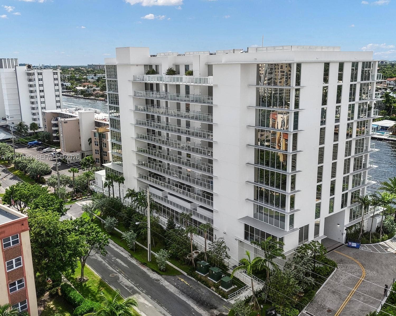407 N Riverside Drive, #604, Pompano Beach, Pompano Beach, FL 33062 Mid-rise building featuring a white facade, extensive glass paneling, multiple levels of private balconies with railings, and waterfront positioning