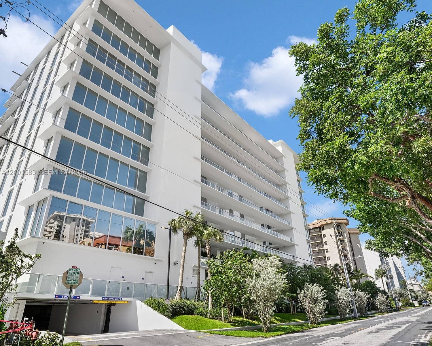 407 N Riverside Drive, #604, Pompano Beach, Pompano Beach, FL 33062 Mid-rise building exterior featuring full-height glass windows, private balconies with glass railings, and a subterranean garage entrance