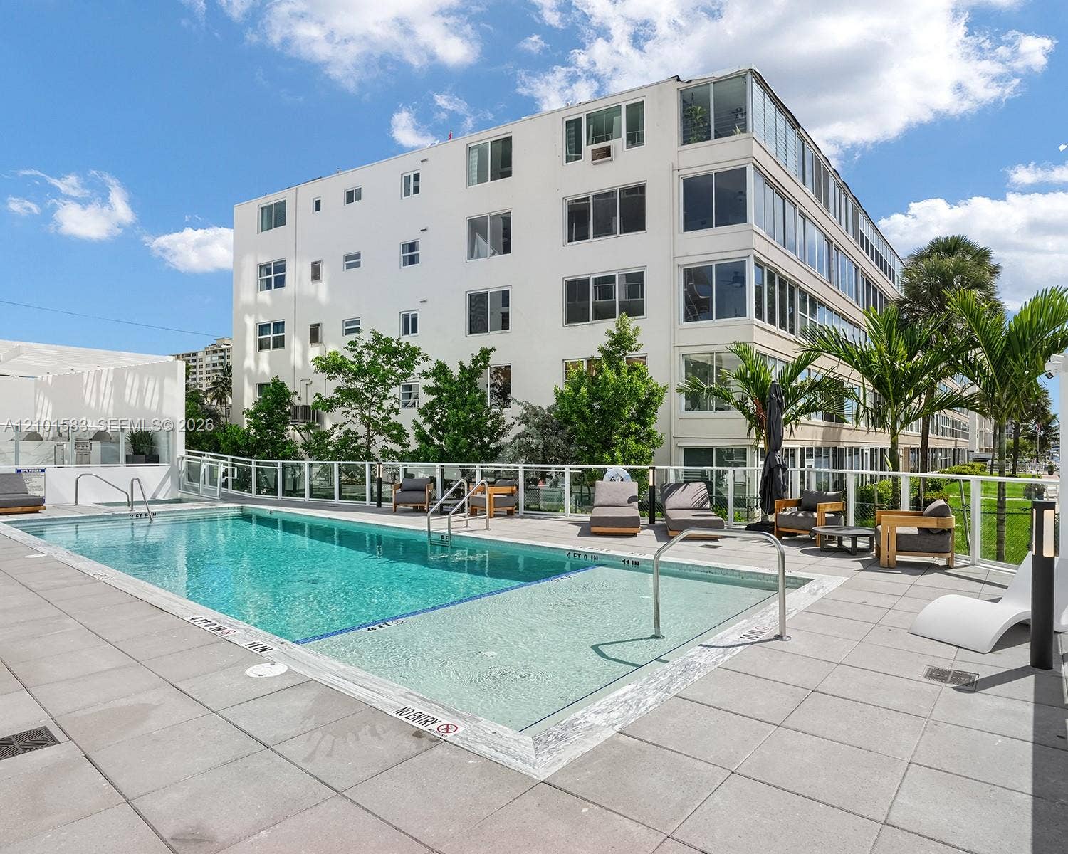 407 N Riverside Drive, #604, Pompano Beach, Pompano Beach, FL 33062 Outdoor swimming pool with a sun shelf, stone-tiled pool deck, and perimeter glass railing