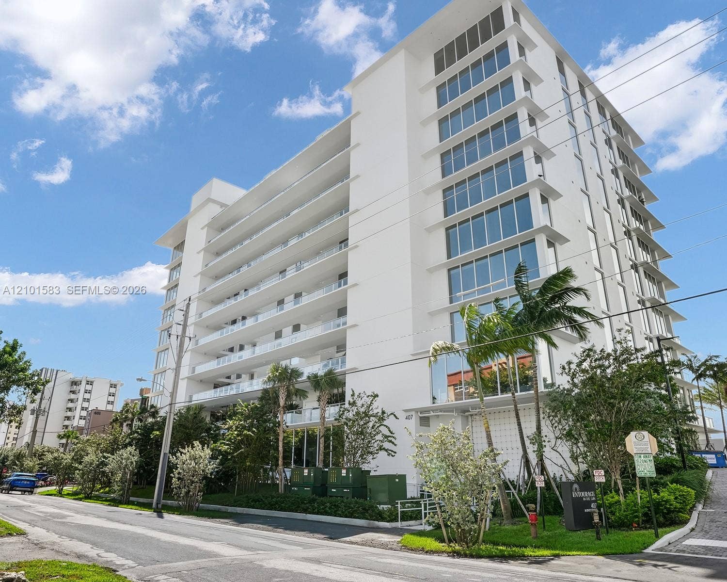 407 N Riverside Drive, #604, Pompano Beach, Pompano Beach, FL 33062 Modern mid-rise building exterior featuring a white stucco facade, expansive glass windows, and multiple stories of private balconies with glass railings