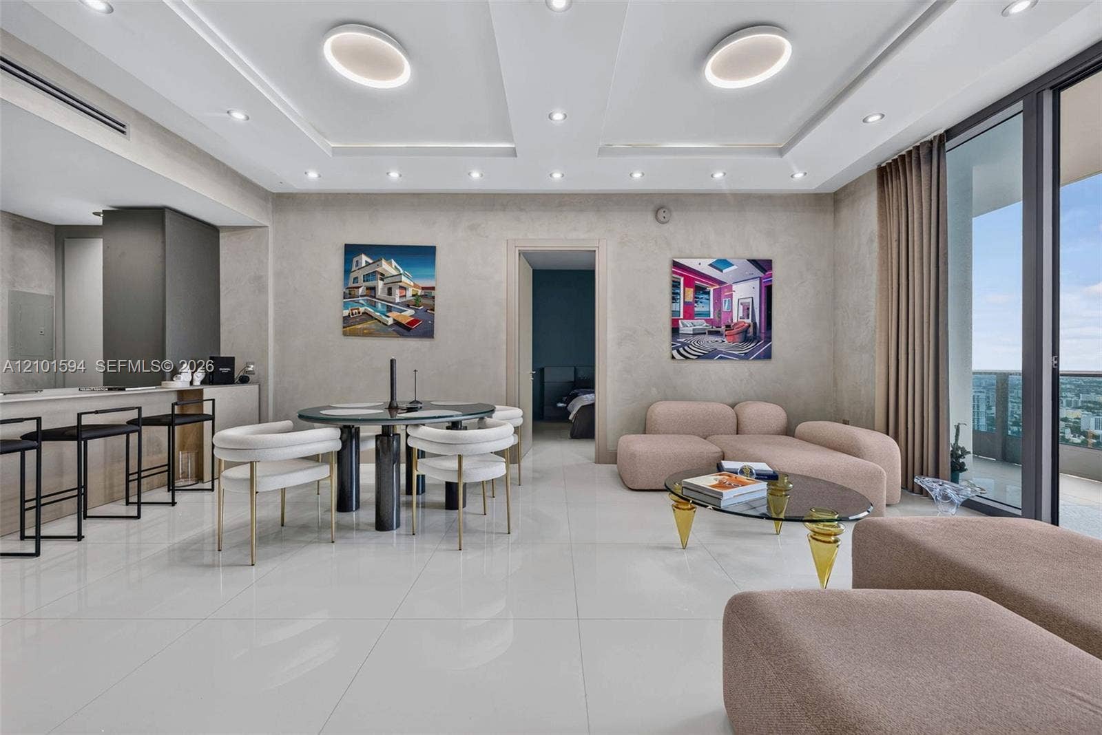 Bright open living and dining space with expansive windows and city views.