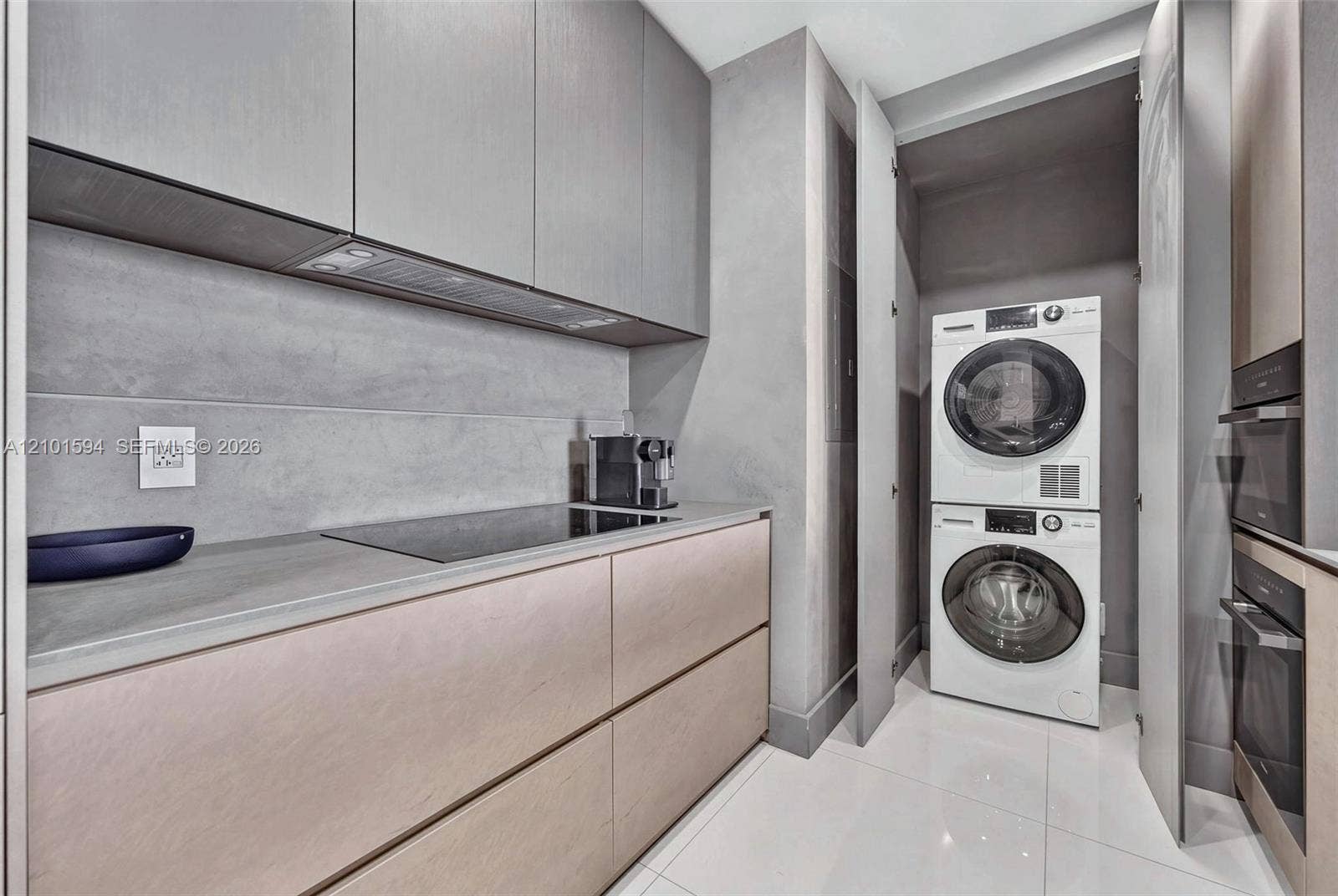 Separate laundry area with full-size stacked washer and dryer.