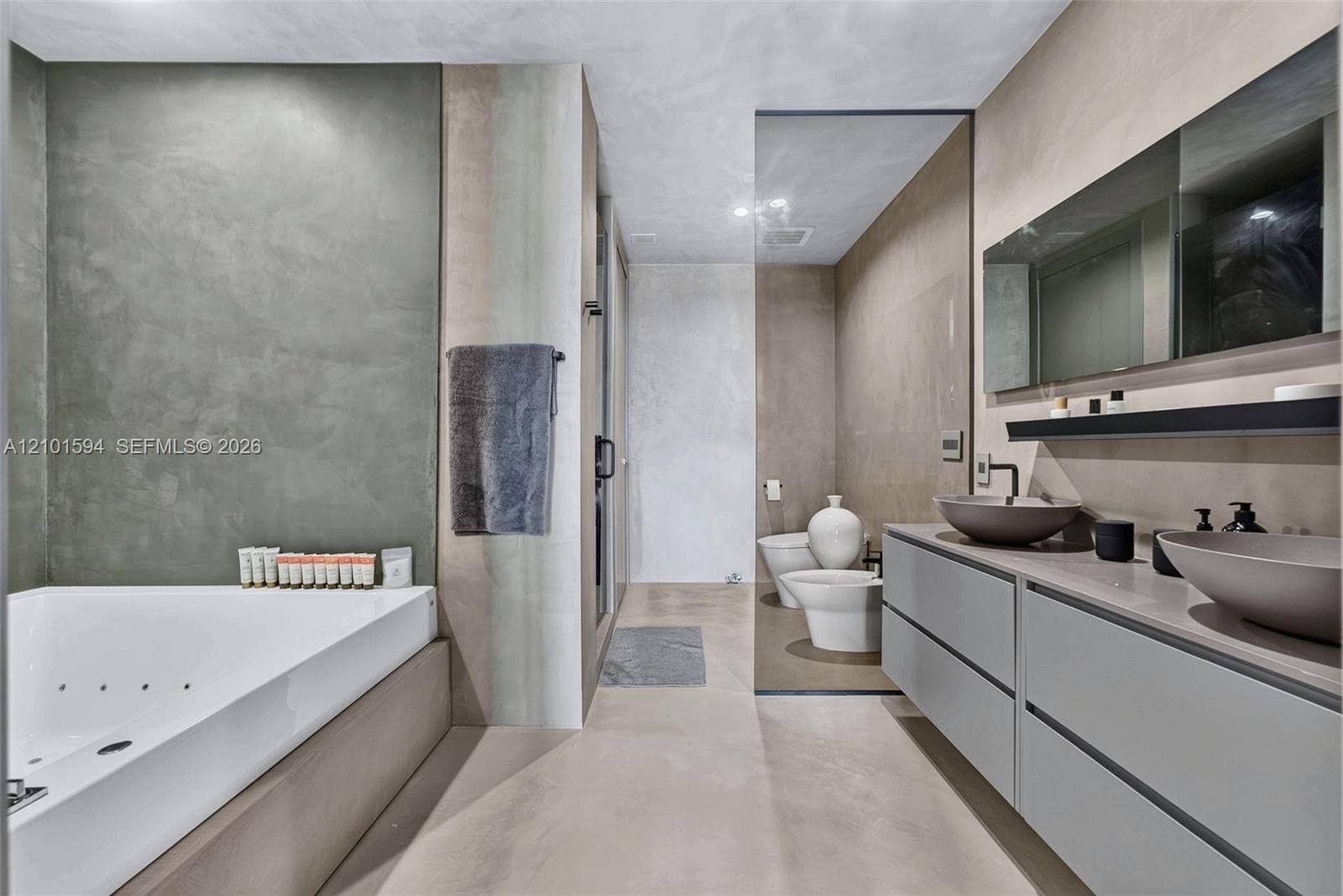 Primary bathroom with oversized spa tub, glass-enclosed shower and dual-sink vanity.
