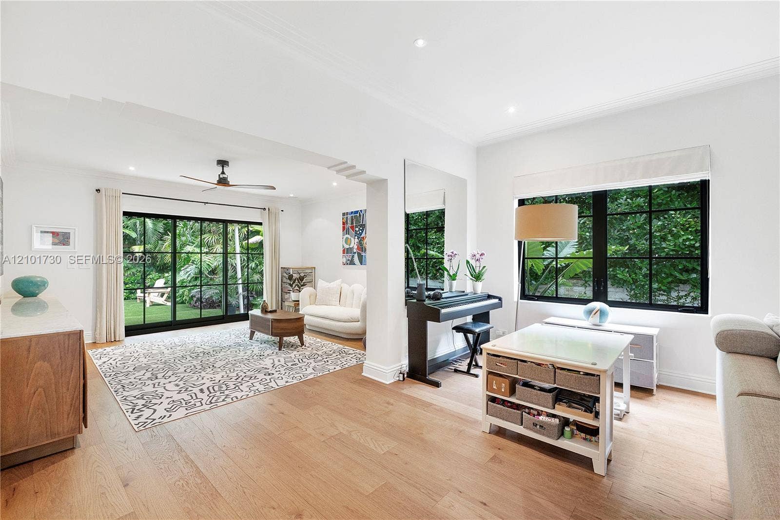 435 W 51st Street, Miami Beach, FL 33140 Open-concept interior featuring light wood-finish flooring, recessed lighting, and large windows with black mullions
