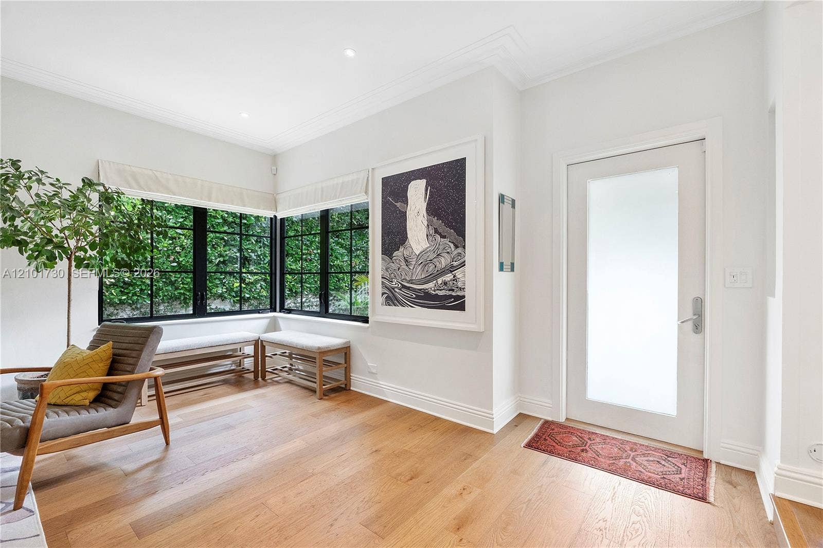 435 W 51st Street, Miami Beach, FL 33140 Entryway featuring wide-plank wood-finish flooring, recessed lighting, crown molding, a frosted-glass pane entry door, and floor-to-ceiling corner windows with black mullions
