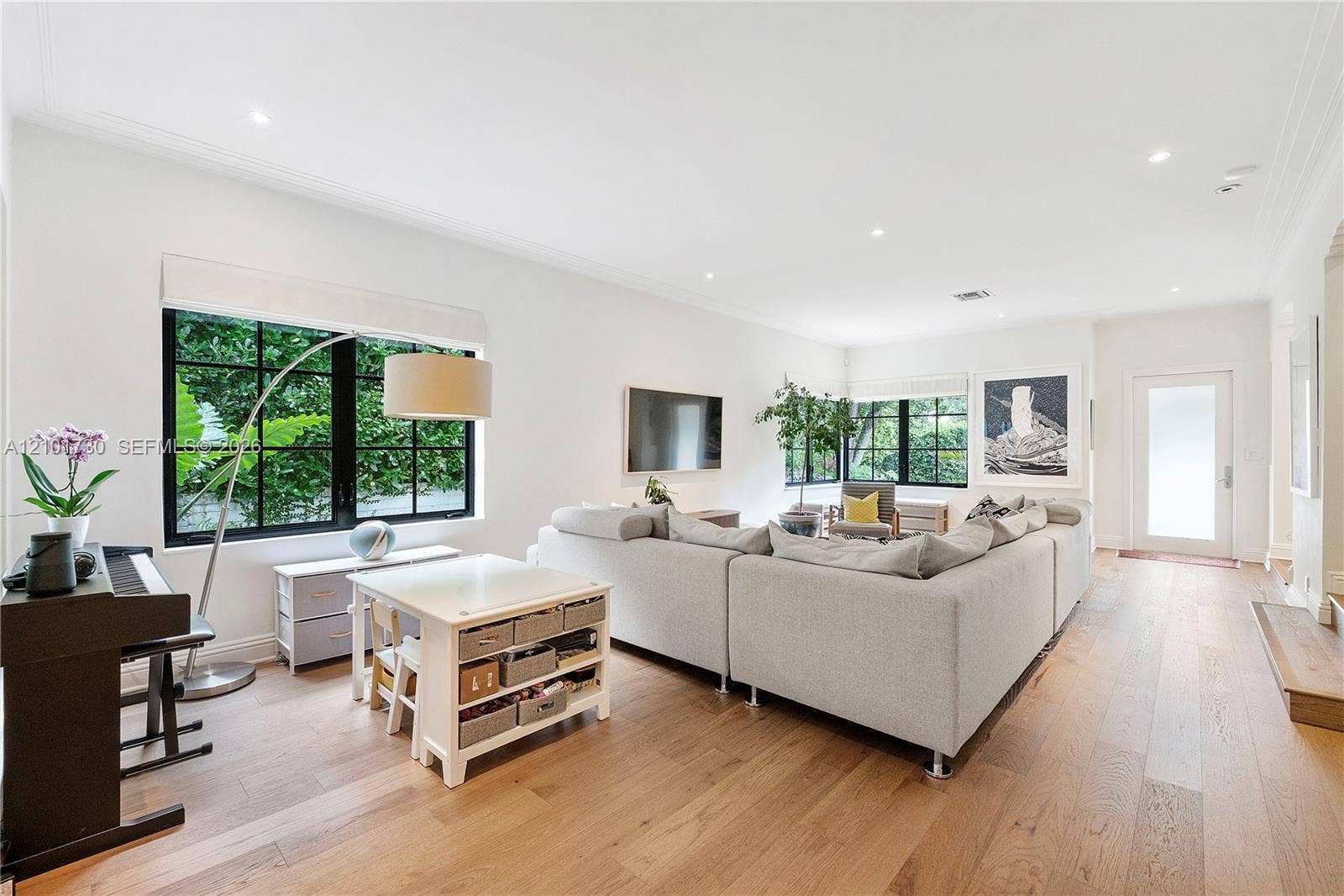 435 W 51st Street, Miami Beach, FL 33140 Open-concept room featuring wide-plank wood-finish flooring, recessed lighting, and large windows with black frames